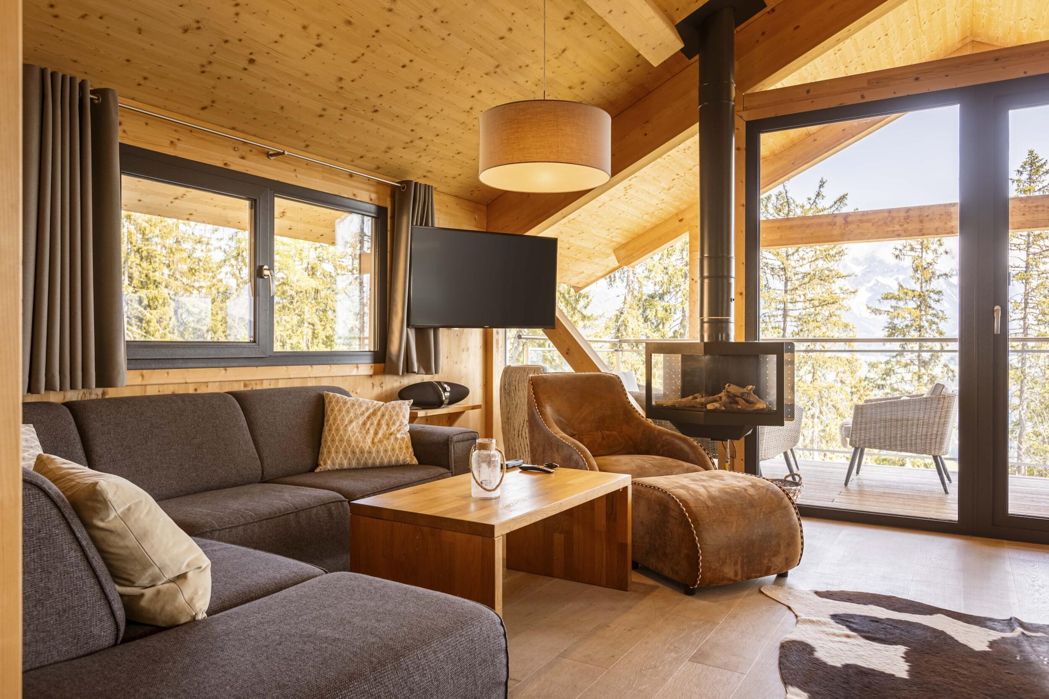 "Discover the epitome of alpine elegance in our Superior Chalet, offering 120 m² of stylish living space for up to 9 guests. Perfectly designed for groups or families, this chalet combines modern amenities with stunning natural beauty to create an unforgettable retreat. 
The chalet features four beautifully furnished bedrooms: three with comfortable double beds and one designed with a single bed and a bunk bed, ideal for children or additional guests. Each bedroom is complemented by its own en-suite bathroom, with three featuring showers and one boasting a luxurious bathtub. Additionally, a private sauna provides a relaxing escape after a day on the slopes or trails. 
Enjoy breathtaking views of the iconic Dachstein mountain and the picturesque Enns Valley from two furnished balconies. Whether you're starting your day with a morning coffee or unwinding in the evening, the panoramic scenery will enhance your stay. 
 The open kitchen is a chef's delight, equipped with all the essentials for preparing meals at home. This includes a ceramic hob, oven, dishwasher, and fridge with a freezer compartment. You'll also find cutlery, cookware, a toaster, kettle, and coffee machine. To make your arrival hassle-free, a small starter set with dishwasher tabs, dishwashing liquid, a sponge, garbage bags, a cleaning cloth, and a tea towel will be provided. 
 Highlights of the Superior Chalet include its prime location directly on the ski slope, offering convenient ski-in/ski-out access during the winter months. In the summer, enjoy direct access to scenic hiking trails. Stay connected with free Wi-Fi and stay entertained with satellite TV. 
Please note that all images are sample representations, as each chalet is uniquely decorated to offer a personalized experience. 
 The chalet includes the Schladming-Dachstein Summer Card (mid-May to early November), providing additional benefits and enhancing your stay. Book now to immerse yourself in comfort and natural beauty! "