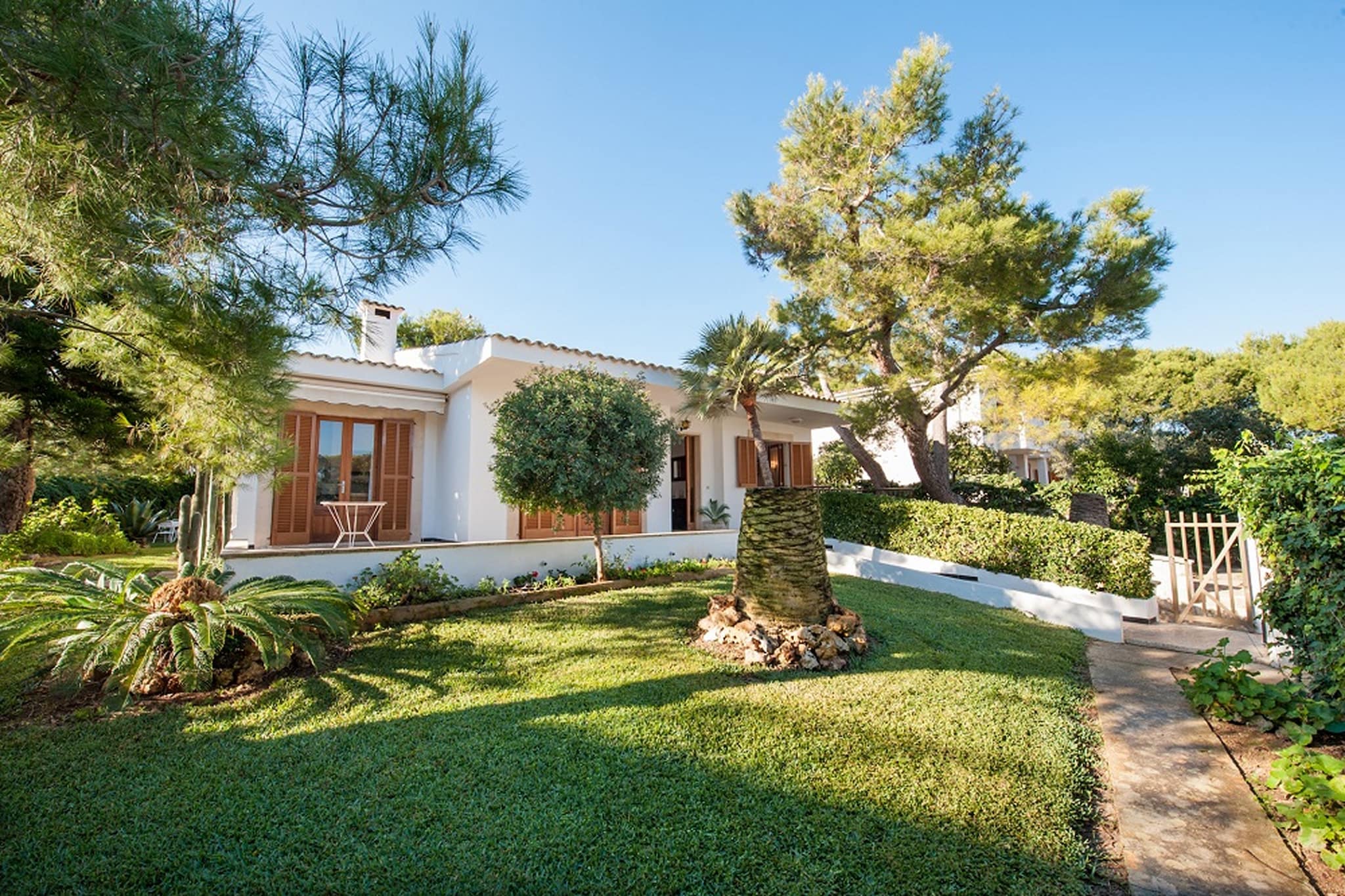 The exterior of the house has a large and well-kept garden where you can relax or sunbathe and an outdoor dining area where you can enjoy the barbecue while you have a drink and watch the little ones playing in the children's area.
Inside the one-storey house you will find a bright living-dining room, equipped with TV, ideal to enjoy your stay and where you can access one of the terraces of the house and the garden. The kitchen is prepared for you to cook with total comfort as it is equipped with all the necessary utensils. From the kitchen we can access the back porch, where there is a small bathroom. The property also has a washing machine, iron and ironing board.
When it is time to sleep, there are three bedrooms. Two of them have two single beds and the other one has a double bed. All of them are spacious and overlook the garden. The house has two bathrooms; one with a bathtub inside and one with a shower outside. The rooms are not equipped with AC, but we can provide fans if you need them. If you wish to travel with your baby, we can also provide a cot and highchair.
The house is close to the beach Playa de Muro, one of the most beautiful beaches of the island. The fine grained, long sand beach is protected by the dunes and it famous for its crystal clear waters. Furthermore, this beach is next to Capellans, where you can have paella or a cocktail in one of the bars. We recommend you to visit the natural park S’Albufera, the genuine villages Alcúdia, Pollença and Artà, the lighthouse of Formentor, the zone Cap de Pinar with lots of small bays, the fisher’s town Colònia de Sant Pere, the beach Sa Cànova and much more. Consult the advertiser for possible charges. Pets are not allowed. The holding of events is forbidden. There is exterior parking for 1 cars.
Distances
Beach: 0.1 km - Platges de Muro
Airport: 60 km - Son Sant Joan
Golf course: 10 km - Golf Alcanada
Town: 6.2 km - Port d'Alcúdia
Train station: 8 km - Sa Pobla
Bus stop: 0.7 km - Avinguda de S'Albufera
Ferry: 7 km - Port d'Alcúdia
Hospital: 3 km - Hospital de Muro
Guests are kindly required to dispose of all rubbish and ensure the property is properly tidied before departure. Should this not be the case, a charge of €90 will be deducted from the security deposit. Tourist license: ETV/9823Single Rental Registry: ESFCTU00000701100064718100000000000000000000ETV/98234Homerti - Central de Reservas CR/33