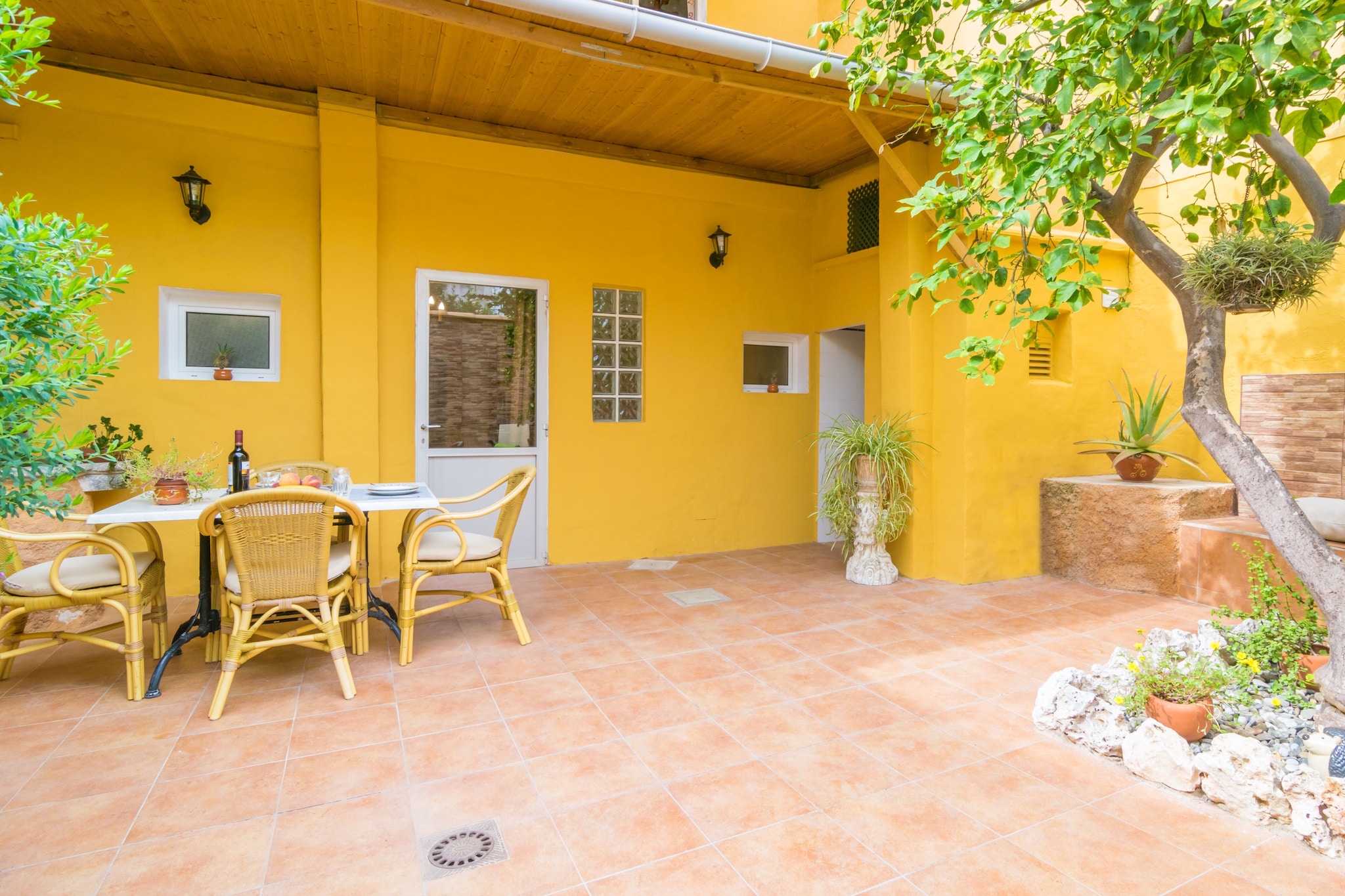 This is a great town house, located on the ground floor of a two-storey building, then becoming a family, quiet and close corner to make your dreams come true in the island. The terrace is beautiful because it has been tastefully decorated and furnished. The combination of the stone walls with the lively colours, the trees, the two sun loungers to enjoy a while under the sun, the built-in bench to enjoy a good reading and, the best of it all, the barbecue for the true professional chefs of meals alfresco. You can cook and enjoy the delicious recipes under the cosy little porch.
Inside, there is an inviting living room with a sofa, two armchairs and air-conditioning, which is the perfect corner to watch the satellite TV, read one of the books of the house, or simply rest. The living area is open to the dining which is equipped with a table with chairs and leads, on the one hand, to the terrace and on the other to the kitchen. This one offers a ceramic hob, oven, fridge, dishwasher, coffee maker and much more, so you can cook as if you were at home. There is one bedroom to rest in the house, and it features a double bed, a wardrobe, a fan and space to prepare a cot if you are travelling with your baby. Finally, there is a shower bathroom for the whole accommodation.
The house is about 200 metres from the centre of this lovely and fascinating city, so you can take a a wonderful walk through the charming streets full of all kinds of shops: fashion, food, shoes, bars, cafes and specially Mallorcan restaurants where you can try our best dishes. The street market takes place on Thursday morning from 7 centuries ago. If you feel like, you can enjoy the town night life where you will find some bars and pubs to have a drink. In relation to the beaches, the nearest one is the paradisaical and extensive beach of Puerto de Alcudia, about 25 km away. But there are many other beaches like Can Picafort, Son Serra de Marina or the ones near Palma in the opposite direction.
You will find neighbours on the top independent floor. Consult the advertiser for possible charges. Pets are not allowed. The holding of events is forbidden.
Distances
Beach: 25.3 km - Puerto de Alcúdia
Airport: 40.3 km - Son Sant Joan
Golf course: 29.3 km - Golf d'Alcanada
Town: 0 km - Inca
Train station: 0.65 km - Inca
Bus stop: 0.65 km - Inca
Ferry: 25.8 km - port d'alcudia
Hospital: 2 km - Inca
Tourist license: ETVPL/12686Single Rental Registry: ESFCTU00000701100033297100000000000000000ETVPL/126865There's a mandatory tourist tax in Balearic Islands, called Ecotasa. All guests, except people under 16 years, have to pay this tax. The amount varies between 0.55€/night and guest during the low season and 2.2€/night and guest during the high season .The tax is reduced by half from the 9th day for your stay.