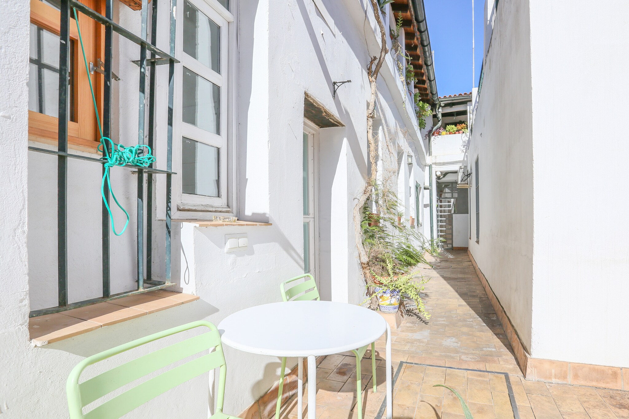 In the exteriors of this beautiful apartment you will find a large Andalusian courtyard that combines traditional elements of Andalusian architecture and design. There is a small table where you can relax and have a drink. Please note that as this is an apartment, you have direct neighbors, so privacy is partial.

The apartment is characterized for being open, all the rooms are communicated and air-conditioned by AC. Inside you will find a kitchen, equipped with ceramic hob, which has all the utensils to cook comfortably. At the time of sleeping you have a very cozy bedroom with double bed and TV, prepared to offer you the rest you deserve. A bathroom with shower completes the stay. A washing machine, iron and ironing board are at your disposal.

The apartment is located in a lively area of Seville, surrounded by pubs, bars, and a vibrant atmosphere that invites you to make the most of the city. Seville is full of color, sound, and movement, making it the perfect place for those seeking an authentic and enriching experience in Spain. With its warm and sunny climate, beautiful surroundings, and vibrant cultural scene, Seville offers something for everyone. It is renowned for its rich history, culture, and architecture, and is one of the most emblematic cities of Andalusia. We highly recommend visiting the Alcázar, a majestic royal palace, or Seville Cathedral, one of the largest Gothic cathedrals in the world.

There is no cot or high chair.
The main entrance door is open from 08:00h to 22:00h, so if you check-in outside these hours you will have to pay 30€ in cash to the person who opens the door. Consult the advertiser for possible charges. Pets are not allowed. The holding of events is forbidden. 
Distances
Beach: 76.4 km - Matalascañas
Airport: 16.6 km - Aeropuerto de Sevilla
Golf course: 7.1 km - Real Club Pineda de Sevilla
Town: 0.2 km - Sevilla Centro
Train station: 2.4 km - Santa Justa
Bus stop: 1.8 km - Estación de Autobues Plaza de Armas
Ferry: 2.2 km - Guadaluxe Cruceros
Hospital: 1.2 km - Hospital Victoria Eugenia Cruz
Tourist license: VUT/SE/05774