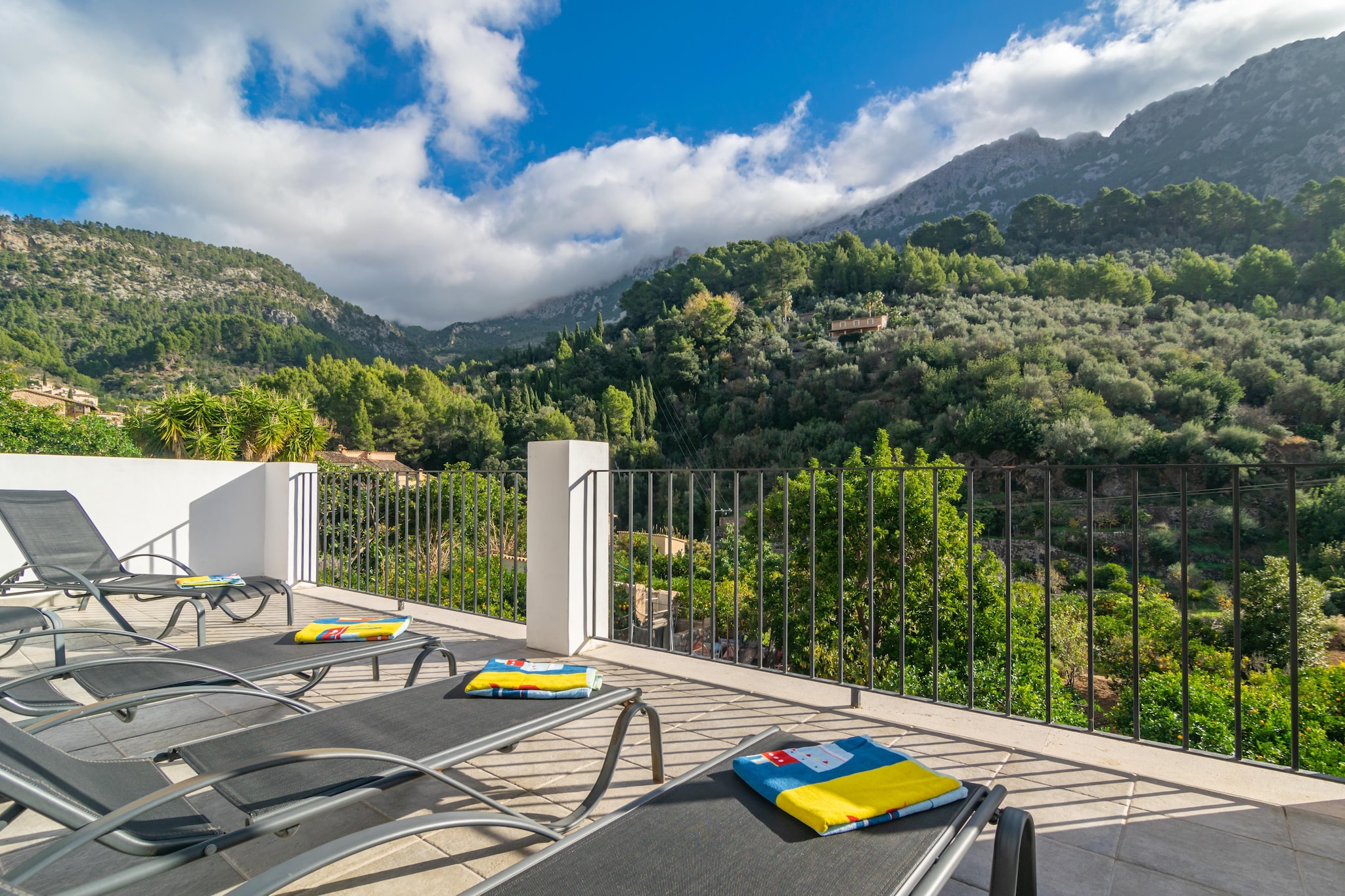 Imagine having breakfast with the magnificent view of the Serra de Tramuntana from the terrace, which has a dining area and sun loungers for sunbathing. The experience becomes even more special with a barbecue, perfect for preparing tasty meals in good company.

Inside this house, which features a rustic facade but a modern interior, you'll find a spacious dining-living room equipped with air conditioning, Smart TV, and two comfortable sofas. The open-style kitchen, with a ceramic hob, is fully equipped to prepare delicious meals. For rest, there is a master bedroom with a double bed, air conditioning, wardrobe, and an ensuite bathroom with a shower. Additionally, there are two additional rooms: one with air conditioning, two single beds, and a wardrobe, and another with a double bed and air conditioning. A second full bathroom with a shower completes the amenities. The house also has a washing machine, dryer, iron, and ironing board. For those traveling with a baby, a crib and a high chair are provided, ensuring a comfortable and convenient stay for the whole family.

Fornalutx is a hidden treasure in the Sierra de Tramuntana. This picturesque village stands among majestic mountains, dotted with olive and orange trees. Its privileged location not only offers spectacular views of the surrounding mountains but also serves as a starting point to explore the trails winding through the Sierra de Tramuntana. These hiking routes reveal stunning landscapes, with ancient olive groves and oak forests. In its central square, you'll enjoy the experiences offered by the local market and its gastronomy. Consult the advertiser for possible charges. Pets are not allowed. The holding of events is forbidden. There are parking space for 1 cars in the garage. 
Distances
Beach: 9 km - Playa de Soller
Airport: 38.3 km - Aeropuerto de Palma
Golf course: 21.3 km - Golf de Son Termes
Town: 0 km - Fornalutx
Train station: 3.7 km - Tren Soller
Bus stop: 0.4 km - Bus
Ferry: 36.8 km - Embarque Palma
Hospital: 27.1 km - Hospital Son Espases
Tourist license: ETV/9200Single Rental Registry: ESFCTU00000702800046781700000000000000000000ETV/92007