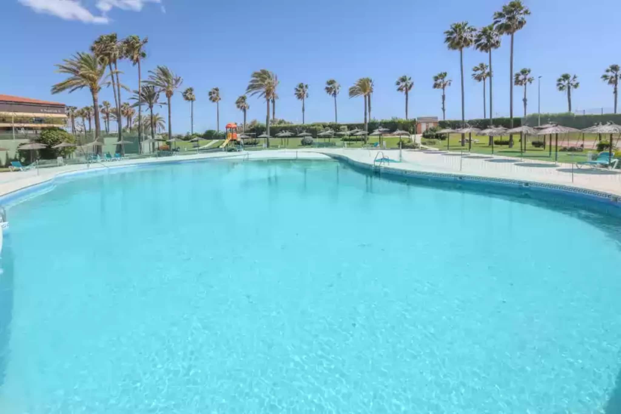 The exterior of the property is ideal for enjoying the southern climate, where you will find a shared chlorine swimming pool with dimensions of 30m x 18m. For the little ones there is a children's playground so that they can enjoy their holidays to the full. There is also a tennis court, a paddle tennis court and even a ping-pong table which you can book for a different kind of morning's fun. At the beach bar you can have a drink after a full day at the beach.

Situated on the first floor with lift, the flat is modern and cosy. You can enjoy a morning coffee on the terrace in the sunshine and tranquillity. Once inside, the living room is equipped with Smart TV and a sofa bed for two guests. It also has two fans. The induction cooker is equipped with all the necessary utensils for you to cook in comfort and feel at home. The bedroom has a double bed and a bathroom with bathtub completes your stay. There is a washing machine, iron and ironing board and if you are travelling with your baby we can provide a highchair and cot.

The flat is located in Isla Cristina, a beautiful municipality on the southwest coast of Huelva. It is known for its golden sandy beaches, its delicious gastronomy and its relaxed and friendly atmosphere. A stroll around the fishing port is fascinating to watch the activity of the fishermen as they unload their catch of the day and then enjoy fresh seafood in the nearby restaurants in the area. The natural park of the Marismas de Isla Cristina is a paradise for nature lovers and is ideal for hiking and cycling. You can also take the opportunity to make excursions to nearby places such as the neighbouring town of Ayamonte, the border with Portugal or the unspoilt beaches of the Costa de la Luz. 

The swimming pool and beach bar is open from 1 June to 30 September. Consult the advertiser for possible charges. Pets are not allowed. The holding of events is forbidden. Please note that the opening and closing dates of the communal pool are subject to community regulations and may vary depending on the season, without prior notice. Updated information will be available upon your arrival.
Distances
Beach: 0.200 km - Playa Islantilla
Airport: 144 km - Aeropuerto de Sevilla
Golf course: 1.8 km - Club de Golf Islantilla
Town: 8.6 km - Isla Cristina
Train station: 40.1 km - Huelva
Bus stop: 0.250 km - Isla Cristina
Ferry: 69.7 km - Huelva
Hospital: 1.8 km - Consultorio Local la Antilla
Tourist license: VUT/HU/02863