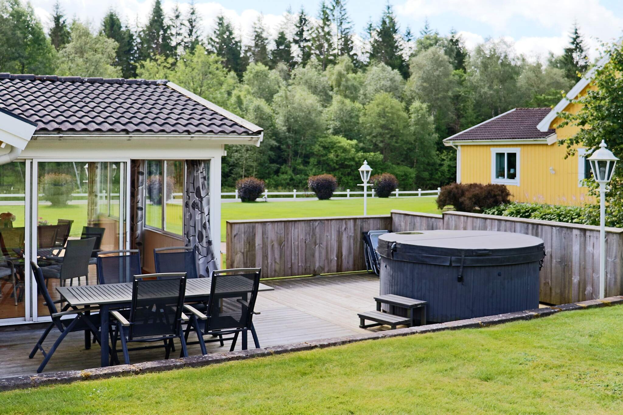 A holiday home with character, well maintained and well equipped in a wonderful rural setting. Here you can find everything for the family that wants to feel freedom and relaxation. The cabin has all amenities for indoor and outdoor activities. Large beautiful plot with many patios and playground equipment. Spa bath and glazed conservatory. From the entrance in the carport you enter the heart of the house. A spacious, lovely living room with both comfortable sofas and a dining table. There is a modern TV and a real brick fireplace with hearth cassette. Here you create a great feeling of coziness at all times and good warmth in slightly chilly evenings. There is also a lovely, well-equipped kitchen with bar counter and bar stools. The cottage has three bedrooms. One with a double bed and two with two single beds each. The bathroom has a shower and washing machine, as well as a sauna at the far end. From the living room you have access to a large glazed conservatory with outdoor furniture and a dining table. Next to the conservatory is a terrace with an outdoor spa bath. Here you can enjoy both summer and winter. The generous plot (part shared with the owner) is fenced, beautifully green and surrounded by forest. There are large grassy areas for all family activities. Here there is a swing and a sandbox and, not least, a fantastically nice little playhouse. All smaller children thrive here. The area where your cabin is located is idyllic with many nice and exciting forest roads. A short trip away is Lake Öjasjön, which has a nice little swimming area. There are several lakes in the area with good fishing. Fishing license applies. A short drive away is Virsehatt, a nature reserve with a fantastic view. At a convenient distance is Oskarström, a smaller resort that has most of what you need during your vacation. There is a much-appreciated adventure pool here, open during the summer. Feel free to take a trip to Simlångsdalen. There is both a public bathing area and several lovely places to visit. A short drive takes you to Halmstad with its white sandy beaches and its cozy inner city. There are several golf courses in the area, the closest is Rydö golf club.