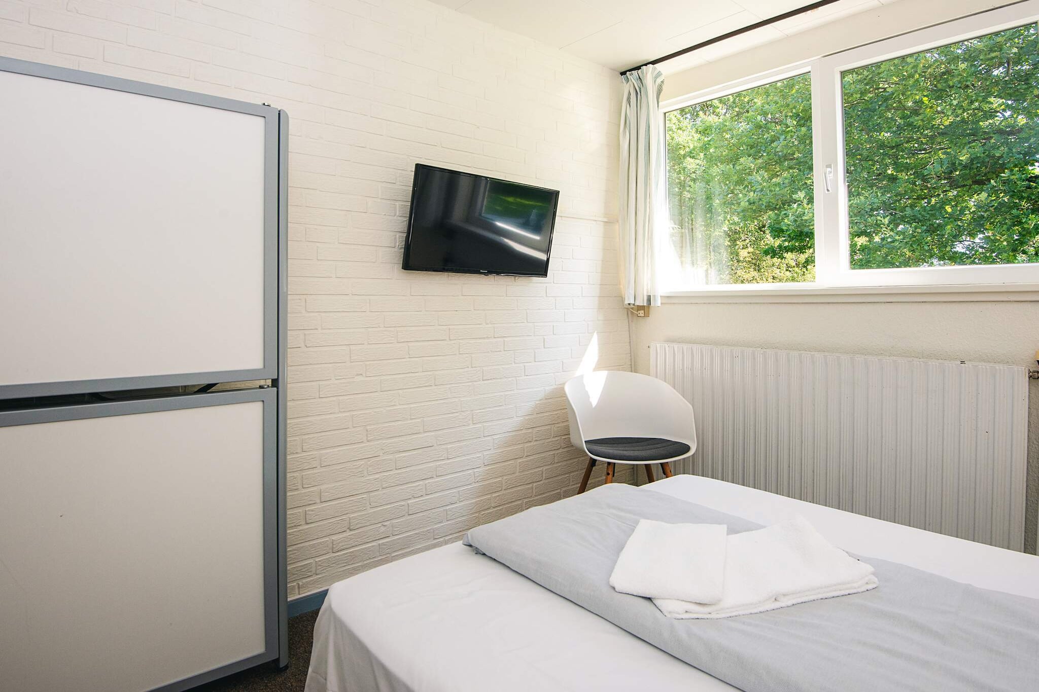 Aabenraa camping is a cozy, well-located site in southern Denmark, just 500 meters from the beach, 300 meters from the forest, and within walking distance of Aabenraa town. Its unique setting offers guests easy access to both nature and local attractions, making it ideal for campers seeking a peaceful stay close to urban conveniences. The site itself is compact and guest-friendly, with short distances between the main building, facilities, and accommodations. Guests can choose from six different types of accommodation, including standard and comfort cabins as well as rooms. Standard cabins vary in size, with some offering kitchenettes and views over the fjord, while the comfort cabins provide modern amenities such as private bathrooms, full kitchens, and spacious terraces. The newest comfort cabins also include underfloor heating and are perfect for small groups or families. Rooms include breakfast, towels, and Wi-Fi, while cabin guests are asked to bring their own linen. Cleaning services can be arranged, and pets are not allowed on-site. Aabenraa Camping also offers a variety of family-friendly activities and facilities on the grounds**:  A centrally located playground featuring a bouncy cushion, climbing tower, swings, slide, and playhouse, open daily from 10 am to 10 pm. A multi-purpose ball field and a beach volleyball court for football, volleyball, and other team games. A large outdoor chess board near the main terrace, perfect for friendly matches in a scenic setting. A common room with TV, table football, board games, books, and a cozy space for guests to relax or socialize.  These on-site features ensure there's something for all ages, making Aabenraa Camping a welcoming place for families, couples, or solo travelers looking to enjoy both leisure and the outdoors.