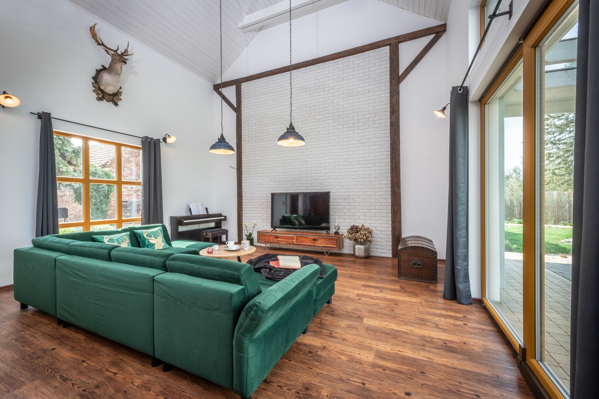 In the charming village of Roprachtice, located in the Liberec region, lies a beautiful holiday home that blends nature with craftsmanship. Every detail of the house, from the handmade furniture to the spruce wood panel walls, reflects the care and love the owners have put into its creation.
This cozy property accommodates 14 people across five bedrooms and three bathrooms. The living room features a panoramic window, allowing you to take in the surrounding natural beauty. Each room is equipped with a television for entertainment, with access to satellite channels or Netflix. The modern kitchen is fully equipped, and a large dining table makes it perfect for enjoying meals together. A small wine cellar is also available, perfect for wine enthusiasts.
The terrace is a perfect spot for relaxation, with comfortable garden furniture ideal for morning coffee or watching the sunset. You can also enjoy barbecuing under the stars or relaxing by the fireplace, with wood provided free of charge. For ultimate relaxation, a sauna and jacuzzi are included in the property, though energy costs are calculated separately.
The Liberec region offers a variety of activities for everyone. Golfers can enjoy nearby courses just 17 km away, while those interested in history can explore the traditions of nearby towns such as Jilemnice (10 km), Semily (15 km), Benecko (16 km), and Ponikla (6 km). Winter sports enthusiasts will appreciate the slopes available for all skill levels, while cyclists and hikers can explore scenic routes.