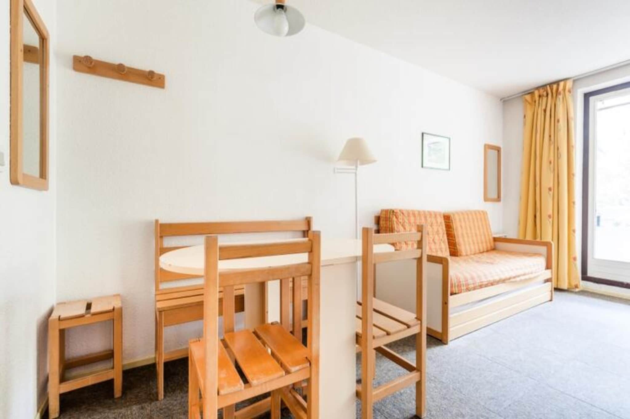 Property, along with its practical and compact layout, comfortably accommodates up to 5 people. The living room features 2 single sofa beds, one of which includes a pull-out bed suitable for children, and there is a cabin area with a bunk bed. The apartment also includes a dining area with a table, chairs, and a bench. A furnished balcony adds to the charm, providing a relaxing outdoor space with tree-lined views. The residence is pet-friendly (subject to conditions) and provides ski lockers for guests. Additional services such as Wi-Fi, bed and bathroom linen, and cleaning are available for an extra charge. End-of-stay cleaning is mandatory.

The residence is ideally located just 500 meters from the resort center, making it convenient for guests to explore local attractions. It is also just 100 meters from a shopping area, allowing easy access to essential stores. The surrounding area offers various activities, especially during the summer season, ensuring a memorable stay. The property’s location also provides easy access to transport links, such as buses and train stations, ensuring smooth connectivity to other parts of the region. The residence blends harmoniously with the resort's architecture, offering a peaceful and central retreat.

The apartment's kitchen area is open to the living room, equipped with basic appliances for preparing meals, enhancing the apartment's functionality. The bathroom is fitted with a bathtub and WC. For convenience, there is additional storage space throughout the apartment. A small television is provided for entertainment. Guests will enjoy the tree-lined views from the balcony, which adds a serene touch to the stay.