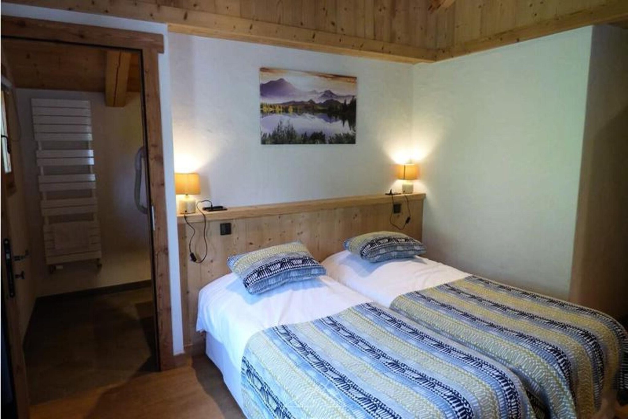 This spacious 185 m², 6-room apartment is located just 300 meters from the center of Grand-Bornand and right at the foot of the cable cars, making it an ideal spot for ski enthusiasts. Set in a fully renovated 5-star farmhouse dating back to the 1830s, the apartment is perfect for larger groups, accommodating 12 to 14 people. Guests can enjoy access to shared amenities including a sauna, hammam, jacuzzi, and fitness room with a weight bench. Beds are made upon arrival, towels are provided, and end-of-stay cleaning is included.

The apartment features a kitchen open to the living room with a wood stove, creating a cozy atmosphere. The sleeping arrangements include three suites, each with a double bed, TV, and en-suite bathroom. Additional bedrooms offer more flexibility, with one bedroom on a mezzanine and two single beds in another. Two extra beds are available upon reservation. The apartment also has a separate bathroom, two separate toilets, a cellar, and a ski locker with a boot dryer for convenience.

Rated 5 stars for 12 people, this property is perfect for families or groups. The tourist tax is additional, and pets are not allowed. Heating is included in the rental, ensuring comfort throughout your stay.
