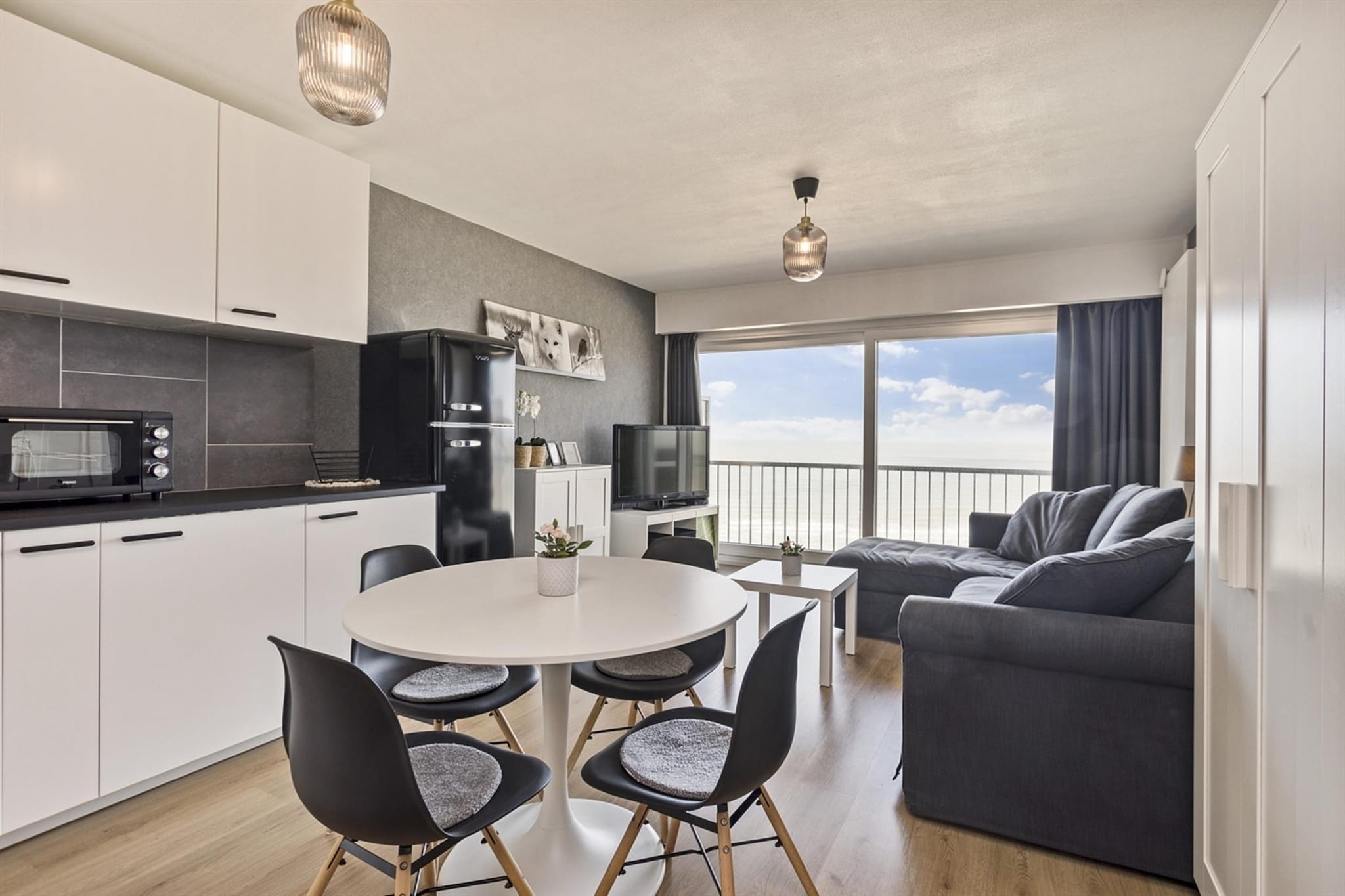 This beautifully renovated studio, designed in a modern industrial style, offers a stylish and comfortable retreat with stunning views of Blankenberge's beach and sea. The studio features a cozy sleeping area with bunk beds, perfect for a small family or a couple looking for a unique stay. The chic bathroom includes a walk-in shower, toilet, mirror cabinet, and washbasin, offering a relaxing space to unwind.

The open-plan living room with a modern kitchen provides a spacious yet intimate environment, ideal for cooking and enjoying meals. The living room opens up to a front terrace, where you can relax and take in the expansive views of the beach and sea. Patio chairs are provided to enhance your outdoor experience, whether you're enjoying a cup of coffee in the morning or a sunset in the evening.

With its sleek design, practical amenities, and prime location, this studio offers the perfect base for a memorable holiday in Blankenberge. Whether youâ€™re relaxing indoors or soaking up the view from the terrace, this apartment promises a comfortable and stylish escape by the sea.