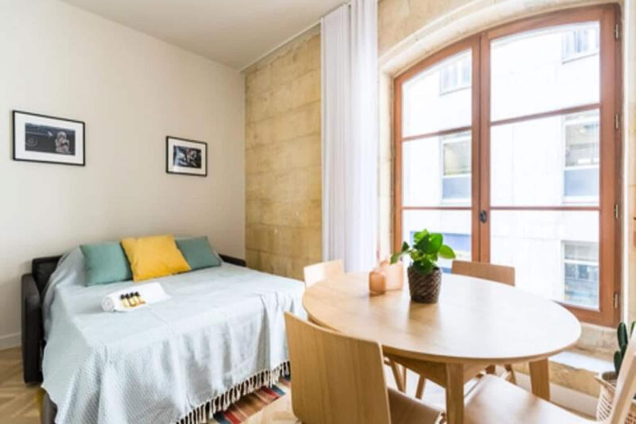Located in the vibrant heart of Bordeaux, this charming 30m² apartment seamlessly blends historical character with modern comfort. With its large bay windows illuminating the exposed Bordeaux stones and thoughtfully curated decor, it offers an authentic and elegant retreat for up to four guests. The space features a luxurious sleeping area with a king-size bed, a cozy sofa bed, a modern kitchenette equipped for all your culinary needs, and a stylish bathroom with a walk-in shower and contemporary fixtures.

Amenities include Wi-Fi, a TV, air conditioning, and a small desk, perfect for work or leisure. Additional conveniences like a washing machine, tumble dryer, and ironing facilities are available in the common areas. Optional services, including breakfast delivery and baby equipment rental, enhance your stay. The property is non-smoking and party-free, ensuring a tranquil environment.

Step outside and immerse yourself in Bordeaux's rich heritage. The apartment is a stone's throw from iconic attractions such as Place des Quinconces, Place de la Bourse, the Grand Théâtre, and Rue Sainte-Catherine, the city's famous shopping street. The Golden Triangle's bustling cafes, boutiques, and restaurants are just steps away, while Bordeaux’s UNESCO-listed historic center invites exploration.

Conveniently connected, the apartment is accessible via tram from both Mérignac Airport and Saint-Jean Station. Parking is available nearby at the Bourse - Jean Jaurès public car park. Whether you're here to explore Bordeaux's vibrant culture, indulge in its renowned wine scene, or simply enjoy its timeless charm, this apartment provides an ideal base for an unforgettable stay.






