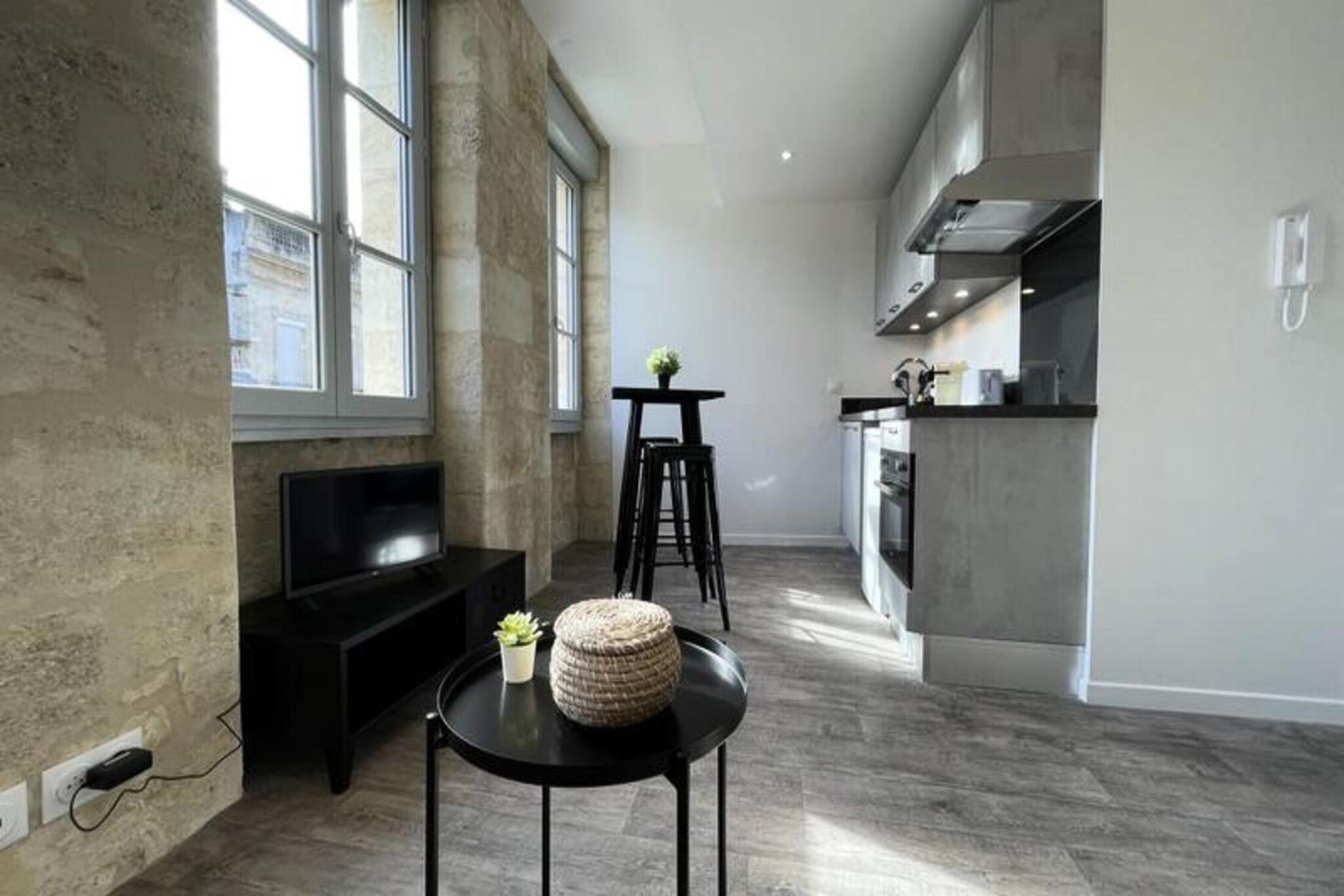 This charming 26 m² studio, recently renovated, blends comfort and style, featuring a sofa bed and modern amenities. It accommodates up to two guests with a fully equipped kitchen, including an oven, refrigerator, coffee machine, and toaster. The elegant bathroom showcases a beautiful Italian shower with cement tiles. Additional amenities include a TV, Wi-Fi, and a baby bed available upon request for an extra charge. Located in the heart of Bordeaux’s historic center, the studio offers easy access to nearby attractions.
The prime location places you steps from Place Gambetta, Place de la Victoire, and rue Sainte-Catherine, with tram stops nearby for easy exploration of the city. The vibrant yet tranquil district ensures a perfect balance. Public parking “8 May 1945 – Mériadeck” is a 10-minute walk away, with parking for €20 per day. The apartment is also easily accessible via Mériadeck and Bourse du Travail tram stops.
The studio features original Bordeaux stone, blending historical charm with modern design. The fully equipped kitchen allows for meal preparation, while the luxurious bathroom adds a contemporary touch. Breakfast delivery services are available. Pets are not allowed, and a security deposit is required upon booking.