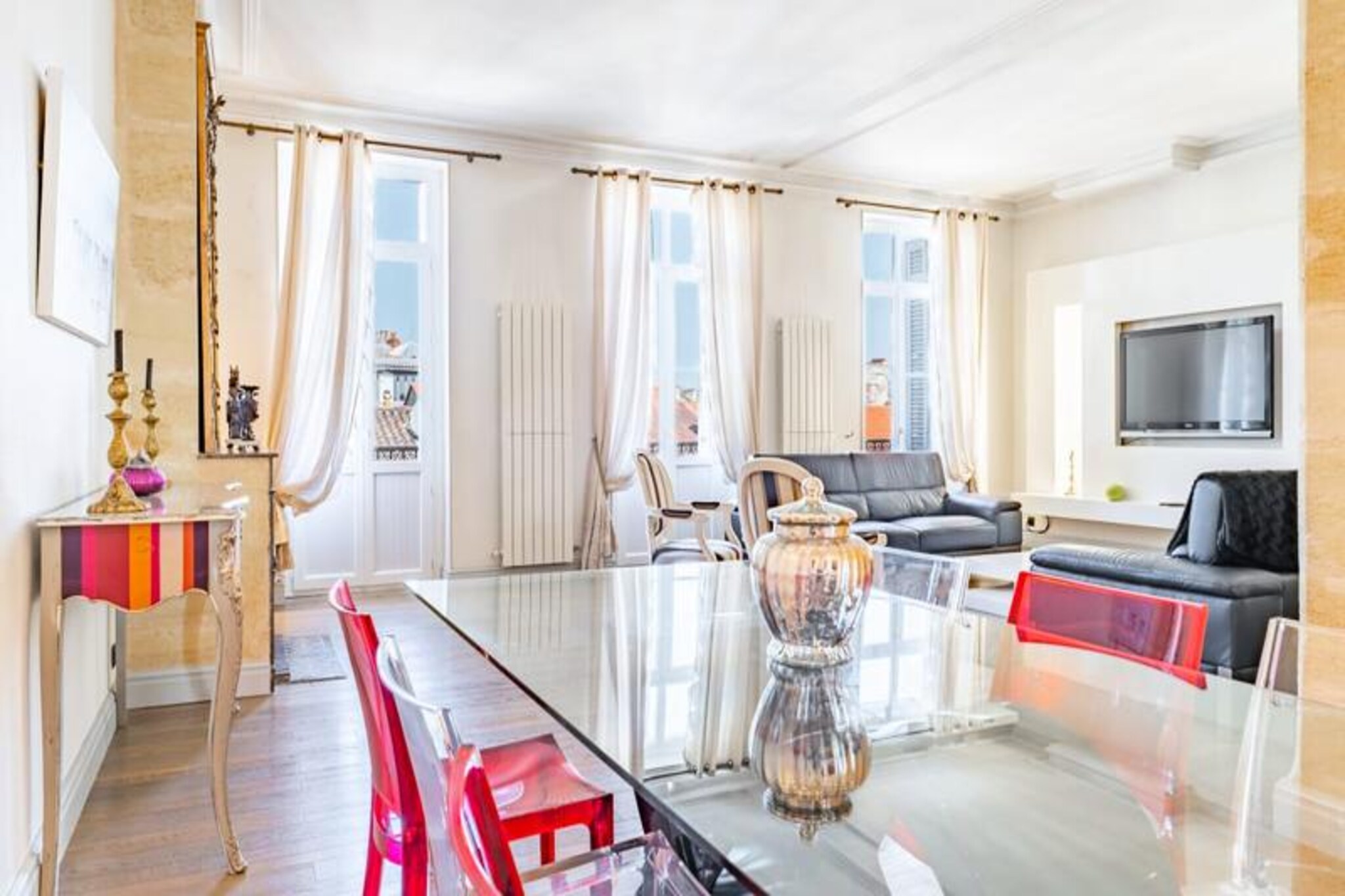 This spacious three-bedroom apartment in Bordeaux offers a perfect blend of comfort and elegance, accommodating up to eight guests. It features a welcoming living room with leather sofas, a large flat-screen TV, and high-speed fiber optic internet. The dining area, adjacent to the living room, is set with a large table for eight, while three French windows lead to private balconies that provide a pleasant view. The fully equipped kitchen includes modern appliances, and the apartment boasts bedrooms with memory foam mattresses.

Located in the heart of the historic Saint-Michel district, the apartment is surrounded by rich cultural and culinary offerings. The neighborhood is centered around the Basilica of Saint-Michel and its iconic bell tower. Just minutes away is Place des Capucins, home to Bordeaux's largest market, known for its vibrant atmosphere and rich history. Visitors will find themselves close to antique shops, flea markets, and a variety of local bistros and restaurants. The apartment also offers excellent tram access to key sites, including the Matmut Atlantique stadium and the Bordeaux Exhibition Center.

Further enhancing the experience are features like parquet flooring and contemporary interiors in a historic building. Check-ins are flexible, with additional charges for arrivals after 8:30 PM. A refundable deposit of €750 is required, managed via a secure online platform.