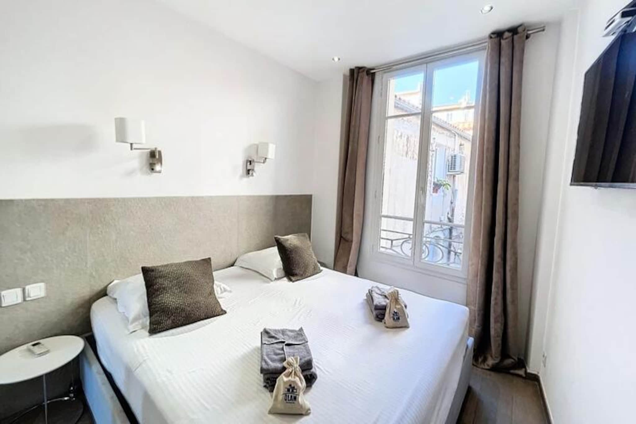 Inside, the spacious main room features a comfortable two-seater sofa bed with premium Bultex bedding (160x200), a large LCD TV with international channels, and an open-plan kitchen. The fully equipped kitchen includes a coffee maker, built-in fridge, toaster, washing machine, kettle, hob, microwave, extractor fan, dishwasher, oven, and tableware for six. A round dining table with six chairs completes the living area.
This beautifully refurbished 3-room flat, spanning approximately 60 m², offers a contemporary and refined space ideal for both holidaymakers and conference attendees. Located in the vibrant heart of Cannes, it combines modern comfort with a prime location near the city's best attractions. The flat is situated on the first floor of a charming building overlooking the bustling Provençal market on Place Gambetta, surrounded by shops and local amenities. Just 150 meters from the SNCF train station, 200 meters from the famous Croisette, and around 500 meters from the Palais des Festivals, it places you in the center of Cannes’ dynamic life.
Staying here means you'll have easy access to a variety of attractions, including the sandy beaches along the Croisette, luxury boutiques on Rue d'Antibes, and the vibrant Gambetta market, perfect for sampling local produce. Public transport links are close by, with the train and bus stations just a short stroll away. This flat offers a blend of style, convenience, and access to all the charm Cannes has to offer.