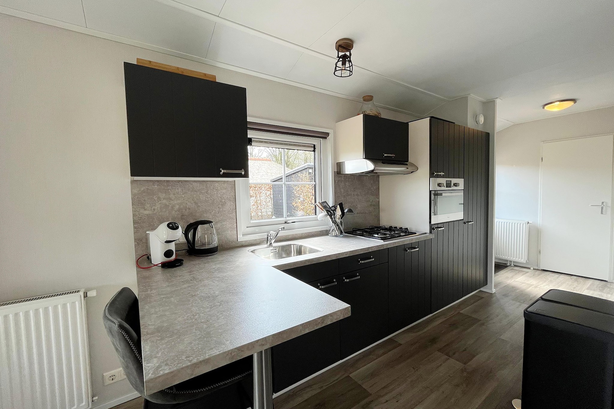 Ground floor: (Living room(TV, seating area), open kitchen(electric kettle, coffee machine, combination microwave, dishwasher, fridge), bedroom(bunk bed), bedroom(double bed), bedroom(single bed, single bed), bathroom(shower, washbasin, toilet))\n\ngarden doors, terrace, garden, garden furniture, parking