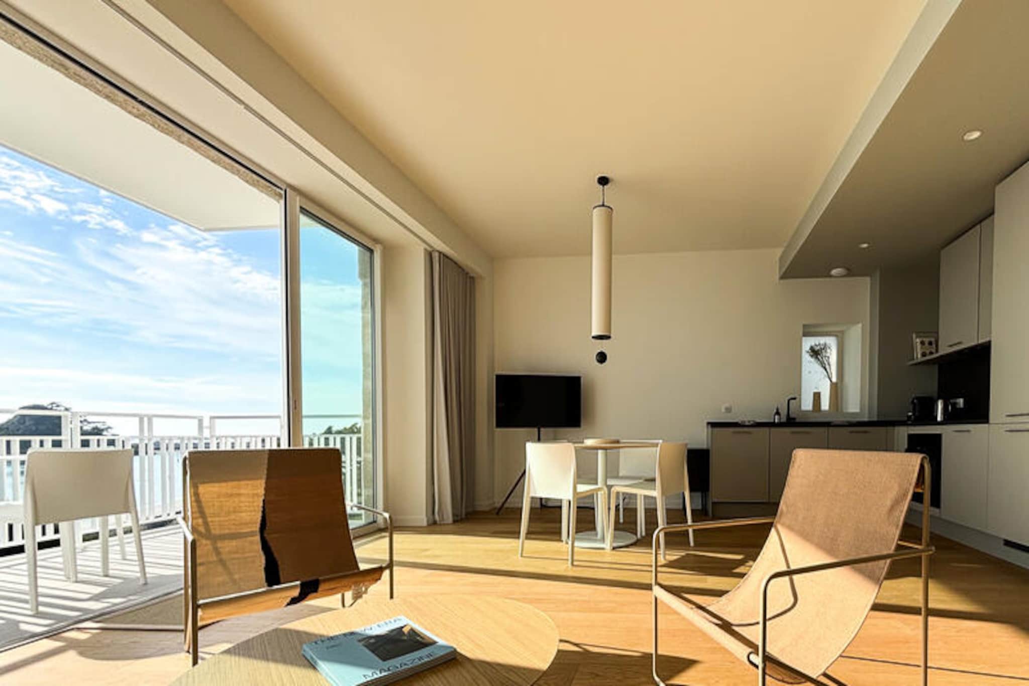 Welcome to “Les Meloines”, our magnificent 3-room apartment located in the Center Philippe-Joppé, designed by the famous architectural firm Wilmotte & Associés. With direct access to Tresmeur beach and breathtaking sea views, our accommodation is the ideal place for an unforgettable seaside holiday.


Our spacious 70 m2 apartment, ideally located opposite Tresmeur beach, offers you a breathtaking view of the sea with its three balconies directly overlooking the sea, you can enjoy breathtaking panoramas at any time of the day.

“Les Meloines” includes two comfortable bedrooms, perfect for up to 4 people. The first bedroom is equipped with a double bed, ideal for couples, while the second bedroom has two single beds, perfect for children or friends traveling together.
After a day exploring the natural beauties of the area or relaxing on the beach, you can relax in our bright lounge, equipped with all the necessary comforts. A fully equipped kitchen will allow you to prepare delicious meals with local products that you can enjoy while admiring the sunset from one of our balconies.

You will also have access to an indoor swimming pool heated all year round (15mx4m), allowing you to relax whatever the weather.

A parking space is available to you, with an electric vehicle terminal available. The residence is secure with the presence of a guard on site, ensuring your peace of mind. In addition, an elevator is available to make your travel easier.

Please note that the new Philippe-Joppé Center will officially open on July 13, 2024. The photos provided are not contractual, some are 3D visuals, others were taken during the shooting of the model apartment in February 2024 which presents a atmosphere and furniture similar in every way to those of the "Les Meloines" apartment.

We look forward to welcoming you for an unforgettable holiday by the sea in Brittany. Book now to live a unique experience in our little corner of paradise.
