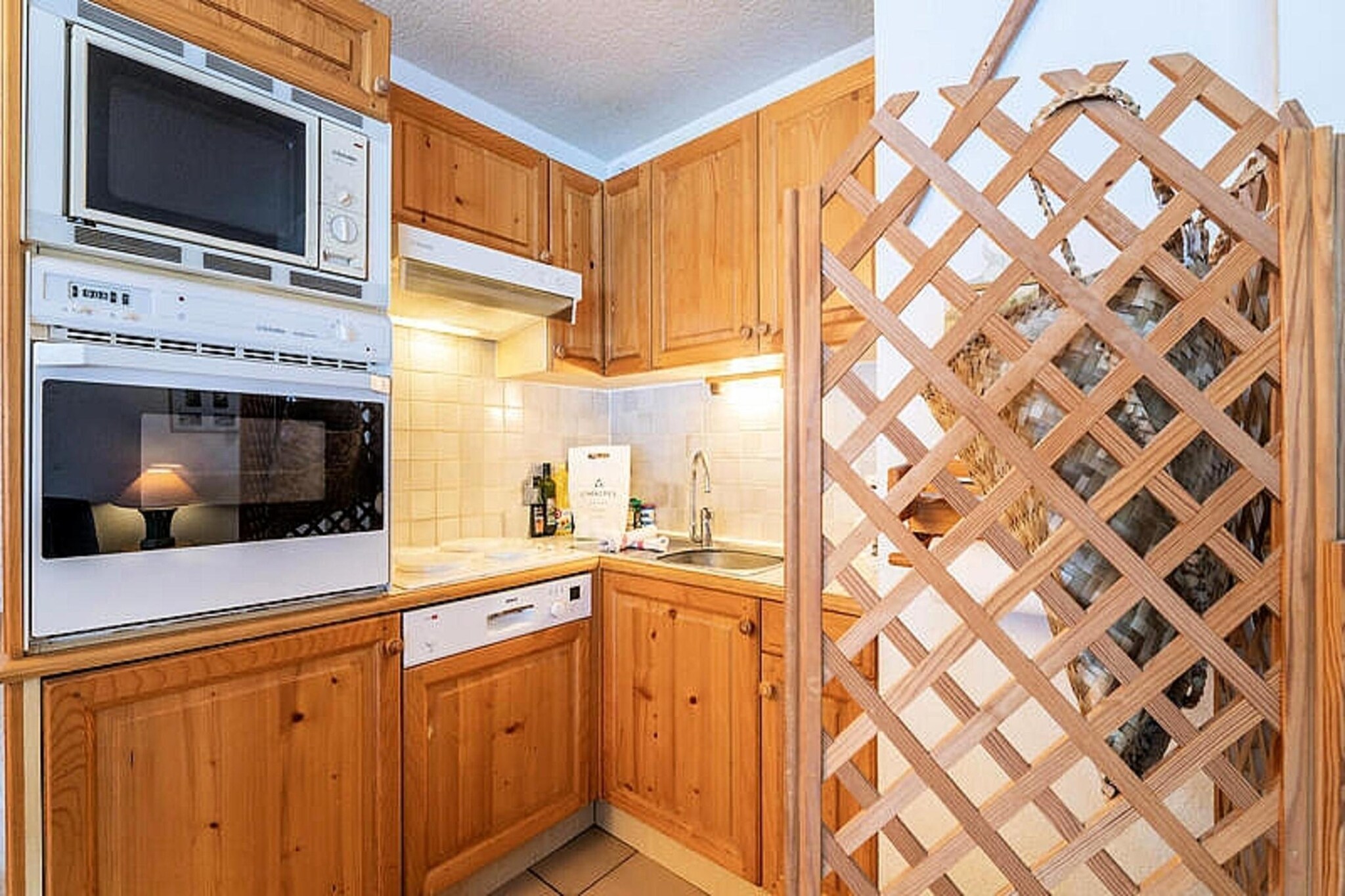 This elegant holiday apartment spans 50 m² and accommodates up to four adults. It offers a cozy living room with a television and dining area, two double bedrooms with serene valley views, and a bathroom with separate toilets. The property includes thoughtful touches like provided linens, beds made upon arrival, and complimentary bathroom products. Please note, pets are not allowed, ensuring a serene and allergen-free environment for all guests.

Nestled at the foot of the slopes and directly facing the Courchevel Le Praz Olympic Tremplins, this apartment offers a prime location for skiing enthusiasts and outdoor adventurers. The nearest ski lift is just 50 meters away, while the charming village center, featuring cafes, restaurants, and markets, is approximately 100 meters from the property. Guests can enjoy scenic trails and alpine views within walking distance, providing the perfect blend of accessibility and tranquility.

The apartment features a fully equipped open kitchen, making it easy to prepare and enjoy meals during your stay. Additional amenities include a ski locker for secure storage, an outdoor parking space within the residence courtyard, and essential heating facilities for your comfort. With its ideal location and modern conveniences, this retreat guarantees a memorable mountain getaway.