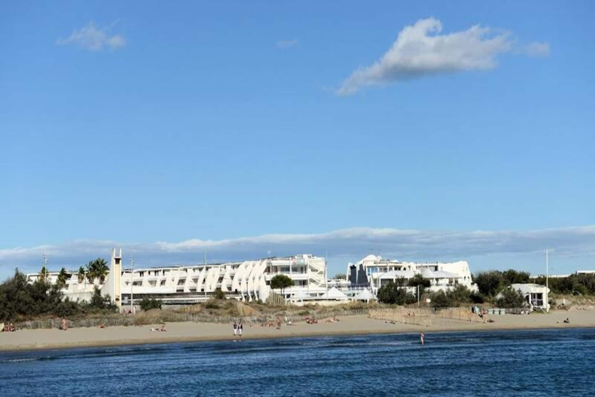 This spacious apartment in a residence near the beach offers a comfortable stay for up to 7 guests. It features a living room with a convertible sofa bed and a single armchair. The apartment includes a bedroom with a double bed and another with two bunk beds. It is pet-friendly (with prior booking) and includes air conditioning, TV, and Wi-Fi. Additionally, the apartment offers two shower rooms and two separate toilets for convenience.

The residence is ideally located in the Point Zיro district, just 20 meters from the beach and 400 meters from local shops and services. It is also adjacent to the La Grande-Motte thalassotherapy center, providing easy access to wellness treatments. Enjoy nearby cafes, restaurants, and markets, or take a relaxing stroll along the beach. The residence offers a tranquil setting for guests to unwind while being close to the area's attractions.

The fully equipped kitchen includes essential appliances for meal preparation, while the two shower rooms ensure comfort during your stay. The residence offers a heated outdoor swimming pool (open until September), free parking, and optional covered parking. Bed and bathroom linens are included, and end-of-stay cleaning is also provided, with the exception of the kitchen area. Additional services such as baby kits and optional cleaning are available.
