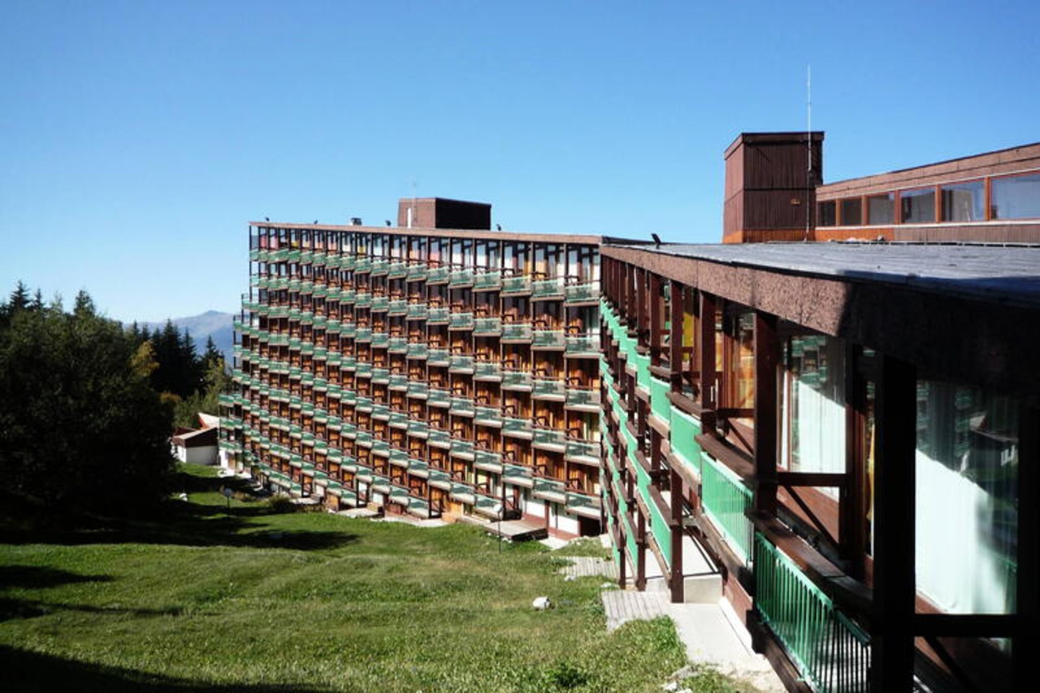 This charming studio offers a cozy retreat for up to five guests, making it perfect for ski vacations or summer getaways. The space includes two single beds in the living area, a mountain corner with bunk beds and a trundle bed (please note the top bunk is not suitable for children under 6). Guests will enjoy the convenience of a South-West facing balcony with stunning views of the slopes and surrounding fir trees. The apartment is pet-friendly for an additional fee, and a television is provided in the living area. Duvets are included, with bed and bath linens available for rent.
Nestled in a prime location, the residence provides ski-in, ski-out access to the slopes, with direct links to the “Vagère” chairlift and “Transarc” gondola. The nearby shopping mall, accessible through a connected residence, features a supermarket, medical office, and is just a short walk from the Tourist Office. The ESF ski school is a 5-minute walk away, while complimentary shuttles provide convenient transport around the resort. Covered parking is available nearby for an additional charge.
The studio boasts a fully equipped kitchen with electric hobs, an oven, microwave, refrigerator, and dishwasher, making meal preparation simple and enjoyable. The bathroom features a bathtub and WC for added convenience. With its excellent amenities, ideal location, and stunning views, this apartment is a fantastic choice for a mountain escape.