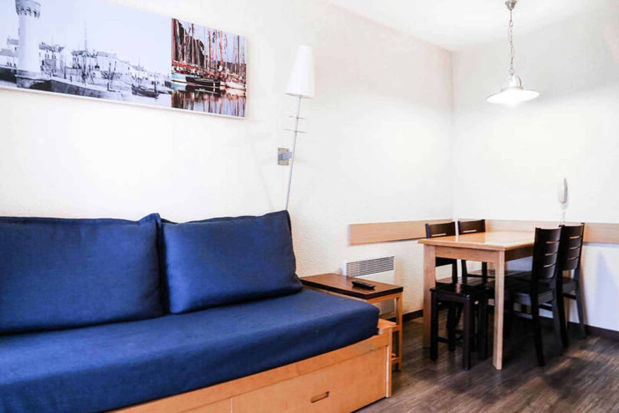 This comfortable apartment, located in a prime seaside location, offers a spacious 35 m² living area and can accommodate up to 4 guests. The apartment features a living room with two sofa beds, one of which includes a trundle bed, ideal for children. The separate bedroom has a double bed for restful nights. Additional amenities include a balcony with a table and four chairs, offering views of the fishing port. The apartment is pet-friendly (additional charge applies) and includes essential facilities such as a TV, storage space, and access to a heated, covered swimming pool.

Situated just 50 meters from the sandy beach and in close proximity to the fishing port, the residence provides a perfect setting for a coastal retreat. Nearby attractions include the Barrière Casino and the thalassotherapy center "Les Cures Marines," both offering relaxation and entertainment options. Enjoy the charm of Belle Epoque-style homes in the area and experience the local gastronomy that defines Normandy. The beachfront location ensures easy access to the water, making it an ideal choice for those looking to explore the sea and nearby cultural activities.

The apartment comes with a fully equipped kitchen area, perfect for preparing meals during your stay. The bathroom is complete with a bathtub and a separate toilet, adding to the convenience of the accommodation. Enjoy the comfort of a well-maintained and practical space with all the essentials needed for a pleasant stay, including a baby kit (subject to availability) and extra services like towel and linen rentals.