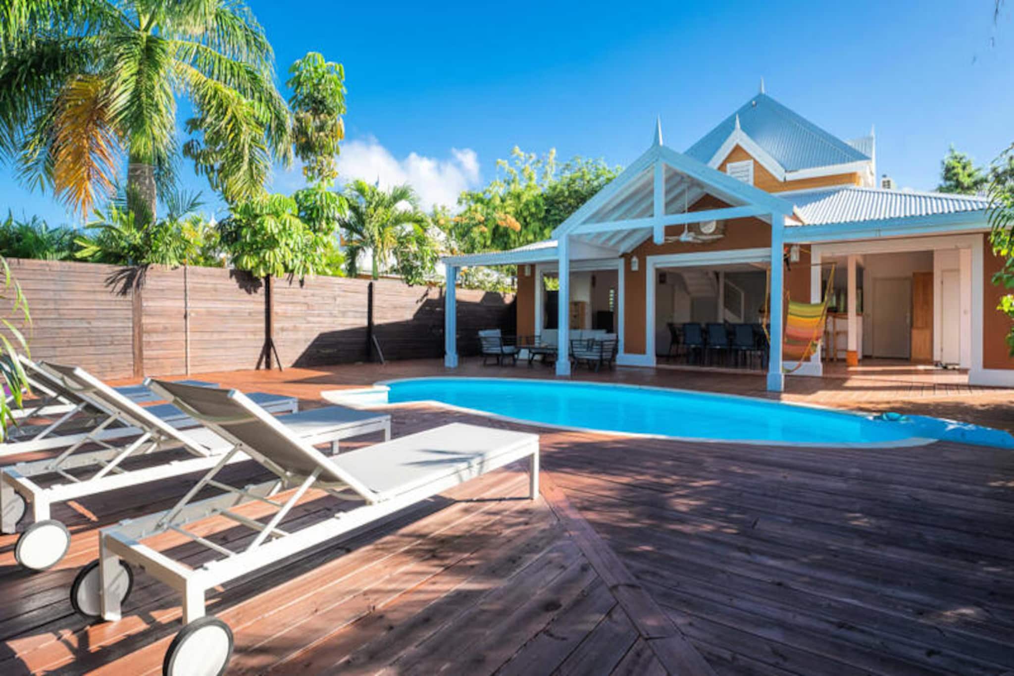 This tropical villa offers an elegant and peaceful retreat with three air-conditioned bedrooms, perfect for up to 6 guests. The master bedroom, located on the upper floor, features a Queen-size bed, a private bathroom with a shower and WC, and a walk-in closet. On the ground floor, there are two additional bedrooms—one with a Queen-size bed and another with twin beds—sharing a bathroom with a shower. The villa is not pet-friendly and maintains a smoke-free environment to ensure a serene atmosphere.

Ideally located in Saint-François, the villa is just 5 minutes from stunning beaches such as Raisins Clairs, Anse à la Gourde, and Anse-Champagne, where you can enjoy water activities. The vibrant town center, marina, international golf course, and casino are all within 10 minutes, offering plenty of dining, shopping, and entertainment options. Additionally, the picturesque Pointe-des-Châteaux and the island of Désirade are a short drive away, providing incredible sights and experiences.

The villa boasts a fully equipped kitchen, ideal for preparing meals in a spacious, open-plan living and dining area. For added convenience, the property includes a water reserve system, internet access, and high-quality linens. Housekeeping services are included to ensure a comfortable stay. A dedicated concierge is available to assist with excursions, vehicle rentals, airport transfers, and other special requests, ensuring your vacation is seamless and memorable.