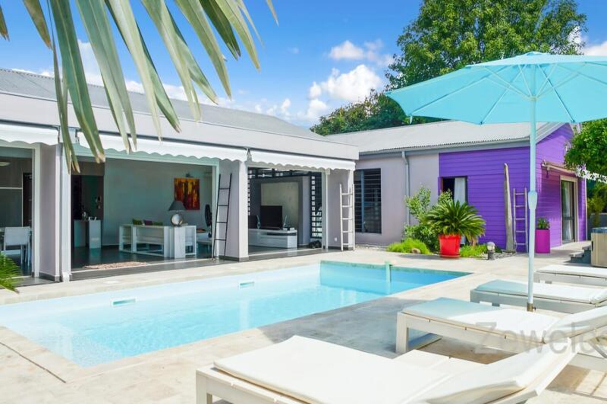 This luxurious 250m² villa offers exceptional comfort with four air-conditioned bedrooms, each with a private bathroom featuring a walk-in Italian shower. High-end bedding ensures peaceful nights. While pet policies are not explicitly stated, it's advisable to inquire directly. The property is located within a private domain and boasts a private swimming pool and jacuzzi. Parties are not permitted out of respect for the neighborhood.

Located in Saint-François on Guadeloupe's Grande-Terre, this holiday home is a short drive from Pointe-à-Pitre airport (45 minutes) and just 5 minutes from the town center, where you'll find a supermarket, bakery, pharmacy, fish market, and night market. The Marina de Saint-François, with its restaurants and boutiques, is also nearby, as are the international golf course, casino, and aerodrome.

The villa features a large 90m² open-plan living room with comfortable seating and direct access to a sunny terrace and the swimming pool. The fully equipped kitchen is a haven for food lovers and includes a wine cellar. Towels, bed linen, and housekeeping services before and after your stay are included. A water reserve system is in place. A dedicated concierge is available before, during, and after your stay to assist with various needs, including excursions, car rentals, airport transfers, and special requests. Welcome refreshments are provided upon arrival.