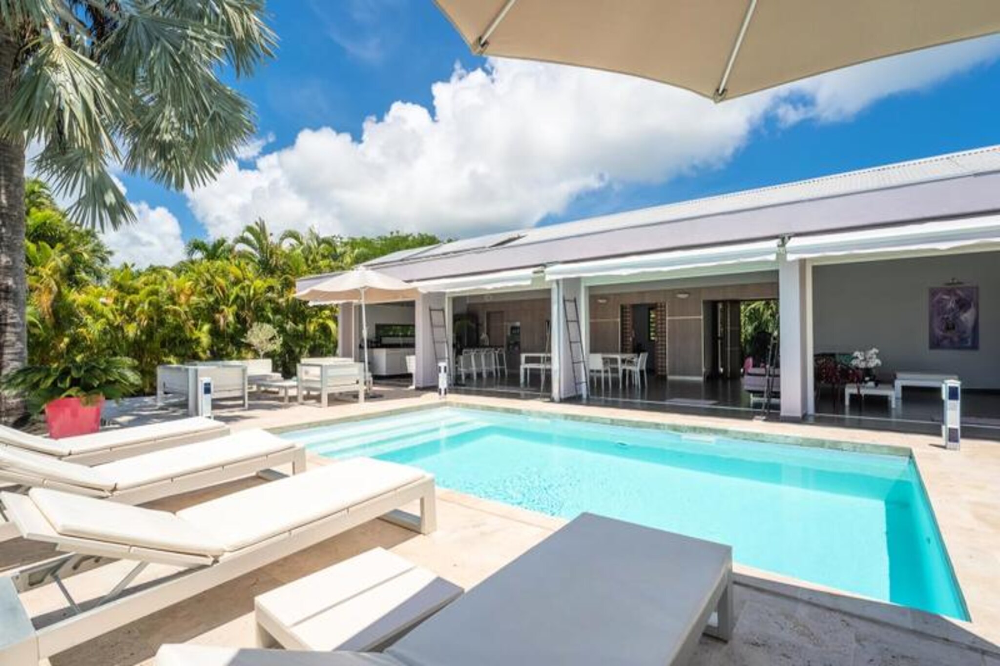 This prestigious villa offers contemporary elegance and Caribbean luxury, featuring four air-conditioned bedrooms with private bathrooms, including walk-in showers. Designed to accommodate up to 8 people, the villa offers comfort and privacy with high-end bedding and tasteful furniture. The property is not pet-friendly, and to ensure tranquility, parties are prohibited. It also provides ample space for relaxation with a private spa, a swimming pool with a lagoon view, and a large living room with direct access to the terrace and natural surroundings.

Located in Saint-François, the villa is just a short distance from local shops, restaurants, and the Marina, where guests can enjoy local cuisine and shopping. The area is also home to stunning beaches, ideal for surfers and wing foiling enthusiasts. For those seeking adventure, the breathtaking views at Pointe-des-Châteaux are just a 10-minute drive away. The nearby international golf course adds to the appeal for golf lovers.

The villa boasts a modern kitchen fully equipped for your culinary needs, including a wine cellar. The spacious living areas include a large dining room and a terrace with barbecue and garden furniture, perfect for relaxing under the stars. The property also features a 3000L water reserve, ensuring peace of mind throughout your stay. Impeccable housekeeping and the option to add baby beds ensure a comfortable and worry-free experience. High-speed Wi-Fi and concierge services complete the luxurious offering.