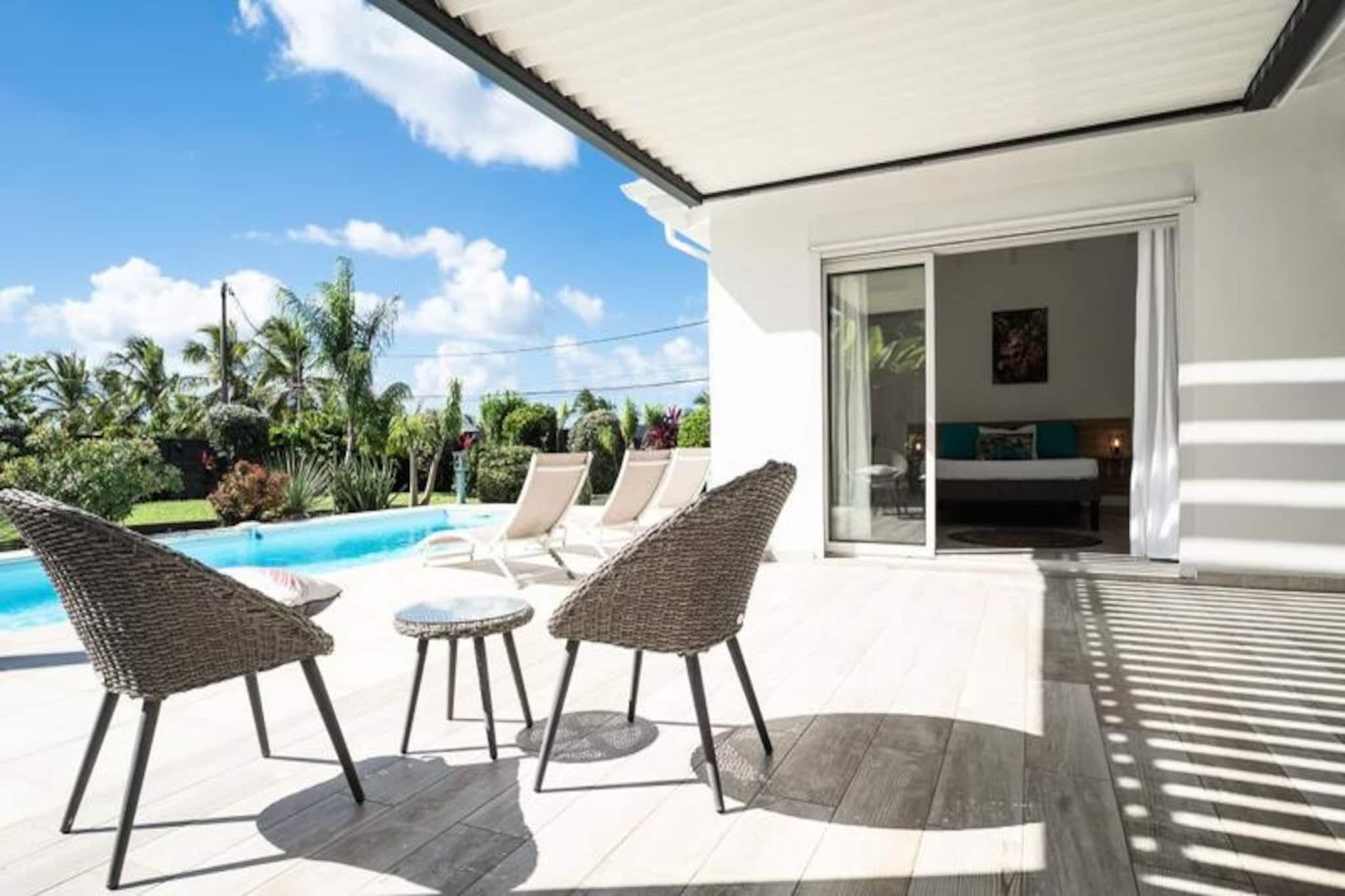 This modern villa is an ideal getaway for up to 6 people, featuring 3 spacious bedrooms, each with its own bathroom and WC. The property offers high-end amenities, including air conditioning in all rooms, towels and bed linens included, and a water reserve system for uninterrupted water supply. The villa is pet-free and non-smoking, providing a serene and comfortable environment for guests. Parties are not allowed, ensuring a peaceful stay for all.
Located in the heart of Saint-François, the villa is just 5 minutes from the vibrant marina, where guests can explore shops, restaurants, and enjoy the lively atmosphere. The local beaches, including Raisins Clairs, Anse à la Gourde, and Anse-Champagne, are all within a short drive. For those interested in water sports, the nearby Port of Saint-François offers surf lessons and other exciting activities. The Saint-François International Golf Course, the casino, and the aerodrome are also within walking distance, making it a prime location for leisure and relaxation.
Inside, the villa features a well-equipped kitchen with modern appliances, including a dishwasher, oven, and fridge/freezer, perfect for preparing meals. The open-plan living area leads to a large terrace, partially covered, overlooking the private pool and garden. With a dedicated concierge available, guests can enjoy exclusive services like excursions, vehicle rentals, and airport transfers, ensuring a luxurious and seamless stay.