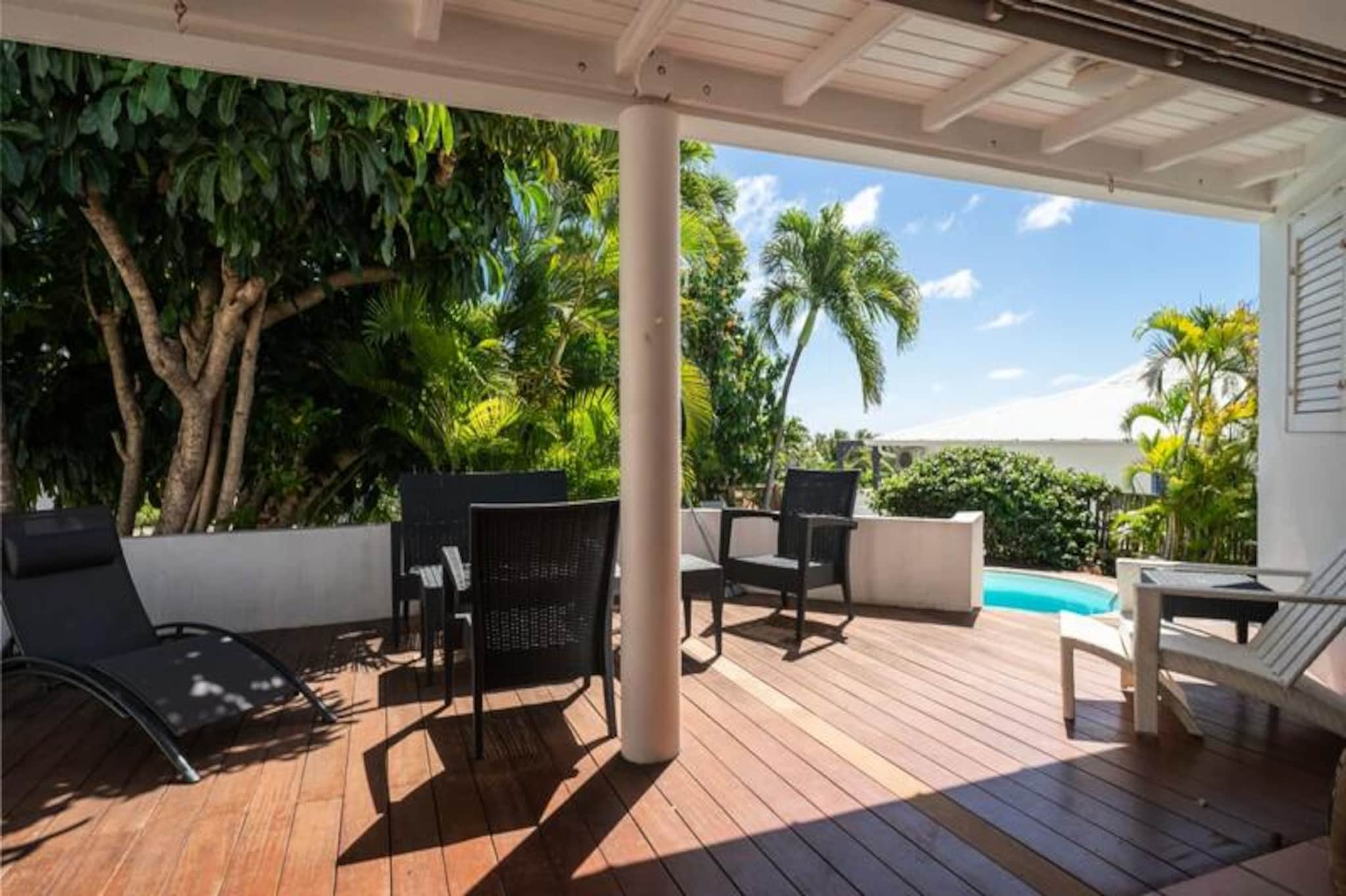 This beautiful villa blends Creole charm with modern luxury, featuring four air-conditioned bedrooms with 160 cm bedding in three rooms and two 90 cm beds in the fourth. The villa comfortably accommodates up to 8 people, making it ideal for families or groups. With a small sea view and surrounded by lush gardens, it offers a serene escape. The property is pet-friendly and includes essential amenities such as towels, bed linen, and access to a water reserve system for added convenience.

Located just 5 minutes on foot from the nearest beach, the villa is also close to the Marina (3 minutes by car), local cafes, restaurants, and shops. The Saint-François International Golf Course, the casino, and the aerodrome are all within walking distance. Explore the vibrant local markets for fresh fish and spices, or enjoy nearby beaches like Raisins Clairs, Anse à la Gourde, and Anse-Champagne. For water sports enthusiasts, the Port of Saint-François offers surf lessons, and Anse-Champagne is perfect for Wing Foil rides.

The villa is designed for tropical living with a spacious living area opening to two shaded terraces, a swimming pool, and an exotic wooden beach. The American-style kitchen is fully equipped, and three spacious bathrooms add to the comfort. Quality housekeeping is provided, ensuring a relaxing stay from start to finish.