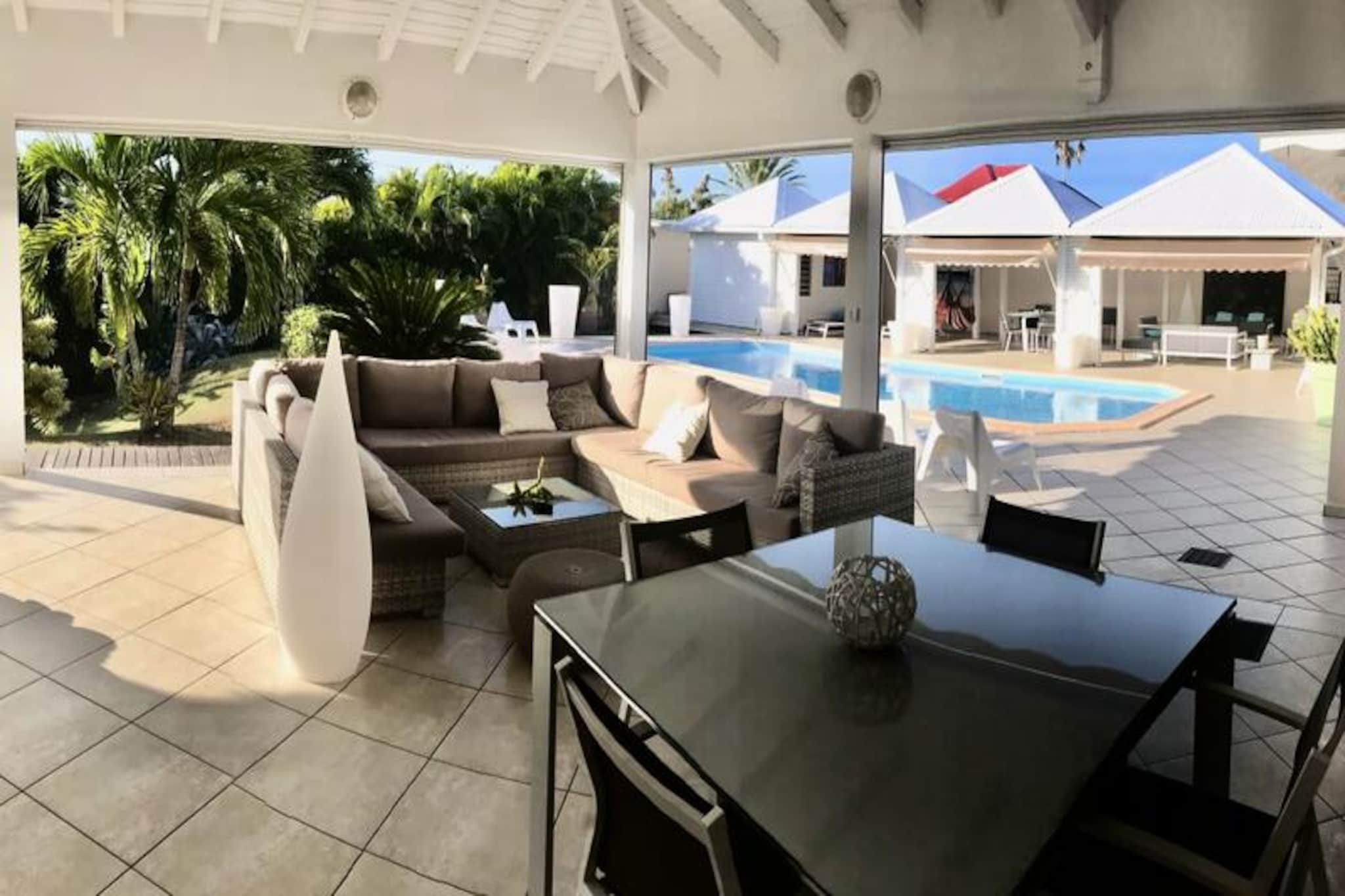 This luxurious villa is a true tropical oasis, featuring three air-conditioned bedrooms with top-quality bedding (two 160 cm beds and two 90 cm beds), ensuring a restful stay. The villa includes two pristine bathrooms and two toilets. Ideal for relaxation, the spacious outdoor areas feature multiple terraces, two lounges, and an outdoor kitchen, making it perfect for outdoor dining and socializing. You will have access to a private swimming pool surrounded by lush tropical greenery, with plenty of room to unwind and enjoy the sun.

Located just 10 minutes by foot from the beautiful Anse des Rochers Beach, the villa offers easy access to local attractions. The town center of Saint-François is only 5 minutes away by car, where you’ll find supermarkets, bakeries, markets, and other essential amenities. Additionally, you are within walking distance to the Saint-François Marina, renowned for its restaurants, shops, and vibrant atmosphere. The villa is also close to the Saint-François International Golf Course, the Casino, and the Aerodrome.

The villa’s interior includes a fully equipped kitchen, both indoor and outdoor, with quality appliances, and a ventilation system for maximum comfort. A water reserve system ensures that you’re always supplied with water. The property is equipped with high-speed internet, and your stay includes housekeeping services before and after your visit. A dedicated concierge is available to cater to your needs and assist with excursions, vehicle rentals, and special requests, ensuring a personalized and exceptional stay.