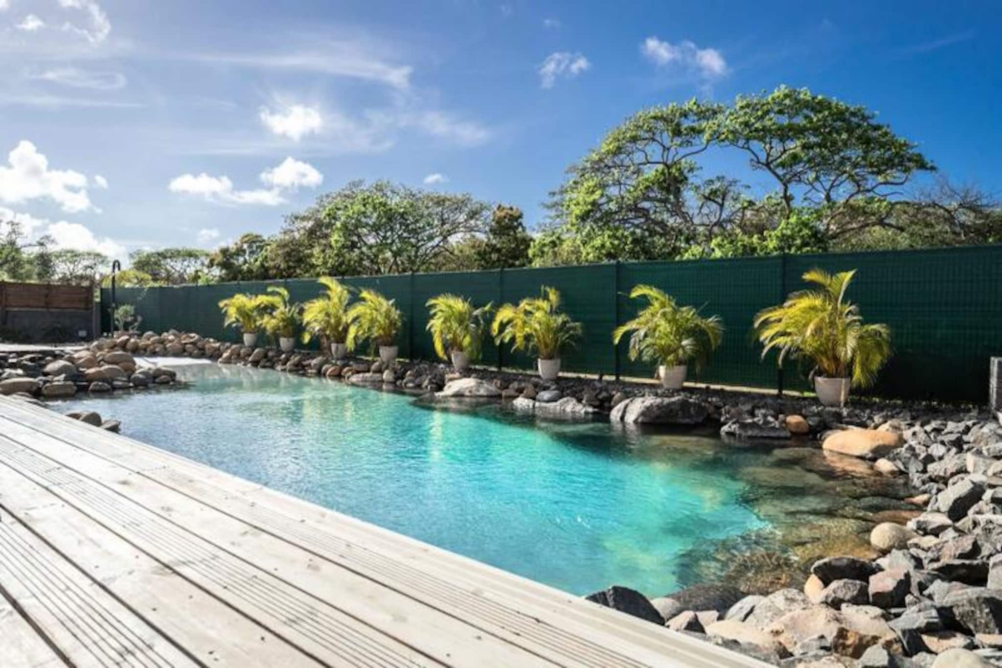 Magnificent architecture with Creole charm. Unique swimming pool lined with river stones. 3 km from beaches, shops and marina. 
The spirit of the river two steps from the lagoon and its turquoise waters. 
The Villa des Rochers is a successful alliance between comfort and love of nature.
Its swimming pool entirely lined with river stones invites you to relax. baths imbued with tranquility; and at; relax on its beach and its terrace for aperitifs in the setting sun. 
The living room overlooked by an incredible roof structure. the cathedral aspect gives it a luminosity. very particular. 
A very well-equipped and spacious, wide-open kitchen with an ultra-friendly bar. A well-organized audiovisual stay. 
Four beautiful air-conditioned bedrooms furnished with 160 cm beds for two of them, a 180 cm bed for the third and two 90 cm beds for the fourth. You will find peace and quiet there. Two convertible sofa beds can accommodate 4 additional people for a total of 12 people. 
Two vibrant and colorful shower rooms complete this sleeping area. 
The charm of natural wood and noble materials throughout your home. a stone's throw from the city center, beaches and marina in a residential area. 

Unique and incredible swimming pool 
Close to all amenities
Layout made with taste

The villa is located in the town of Saint-Fran&ccedil;ois, on the eastern part of Guadeloupe called Grande-Terre. &Agrave; 45 minutes by car from Pointe-à-Pitre airport, it will take you less than 5 minutes to reach the town of Saint-Fran&ccedil;ois and find all the amenities: Commercial space, Supermarket, Bakery, Pharmacy, Market with fish & spices.

You will not miss the unmissable Marina de Saint-Fran&ccedil;ois, where you can enjoy restaurants nearby. the varied menu, and shopping in its many boutiques. The Saint-Fran&ccedil;ois International Golf Course, the Casino, and the Aerodrome are all located within walking distance. just 5 minutes from your luxury villa in Guadeloupe.

The most beautiful beaches of Guadeloupe (Raisins Clairs beach, Anse à la Gourde, Anse-Champagne, la Coul&eacute;e) are located nearby. just 5 minutes from your superb holiday villa. For water sports enthusiasts, the Port of Saint-Fran&ccedil;ois spot offers Surf lessons for all levels, and Anse-Champagne beach is the ideal place. ;al to take his first Wing Foil tacks.

The villa is located at about 10 minutes by car from one of the most visited sites in Guadeloupe: Pointe-des-Ch&acirc;teaux facing the sea. the island of Désirade.

✅  Internet access
✅  Air conditioning in all rooms
✅  Towels and bed linen included
✅  Water reserve system to protect you against cuts
✅  Quality housekeeping hotel management carried out before your arrival and after your departure
ℹ️ Out of respect for the neighborhood, `parties are not authorized`


🛎  The team is ready to go. your service to ensure you have an optimal stay! We attach great importance to your well-being and the smooth running of your stay.

Whether for your accommodation, for your stay or for all of your needs, your dedicated concierge will help you. will be at listen to you so that you have an excellent stay!

🍹  Refreshments and welcome cocktail at your arrival
🤵&zwj;♂️ Your concierge available at any time before, during and after your stay
⛵️ Exclusive services via our partners: Excursions, Vehicle rental, Airport transfer, Special requests
💬 Our selection of local events before your stay (on request)

*Your vacation awaits you, under the Guadeloupe sun* 🏖 ☀️

The concierge will be happy to welcome you. If you haven't contacted him, please contact us. Before arriving at the rental, please call them when leaving the airport.

Deposit (in euros) - 1000
