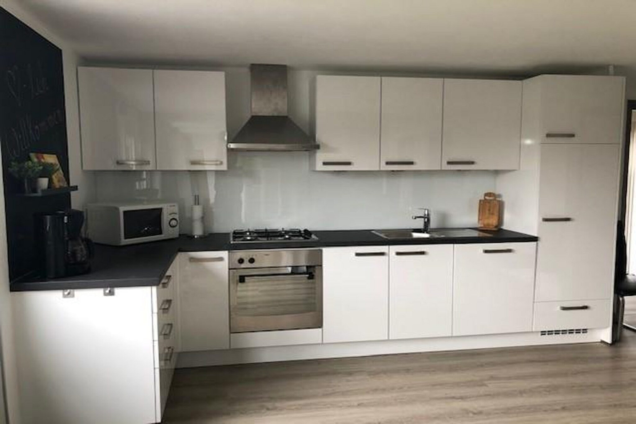 Ground floor: (Living room(TV(smart TV, dutch television channels, german television channels), dining table, seating area), open kitchen(electric kettle, coffee machine(filter), oven, microwave, dishwasher, fridge-freezer, dishes and cutlery(Bowls, chopsticks, plates, cups, etc.)), bedroom(double bed), bedroom(single bed), bedroom(bunk bed), bathroom(shower, washbasin, toilet))\n\ntumble dryer, washing machine, heating(central), terrace, garden, parking