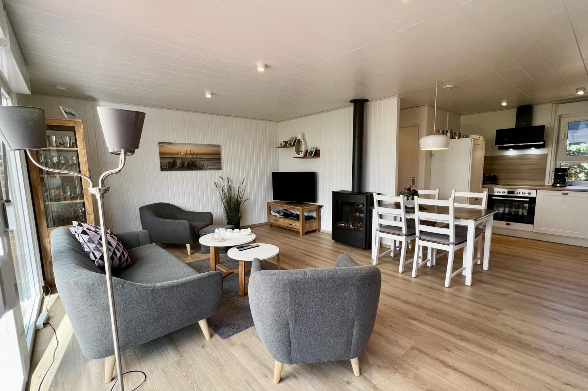 This cozy, detached wooden bungalow is located in the peaceful center of the park, offering a relaxing retreat for up to 4 guests. The bungalow features a fully renovated kitchen (2023), equipped with 4 induction hobs, a grill/oven, microwave, coffee machine, dishwasher, and refrigerator without a freezer compartment. The living room (20.5 m²) is comfortably furnished with a new seating area, including a 3-person couch and 2 armchairs. Entertainment options include a color TV with satellite channels (30 German channels), a radio/CD, and a DVD player. Free Wi-Fi is provided for your convenience.
The bungalow offers two bedrooms, one with a bunk bed (90x200) and the other with a double bed (140x200). The bathroom includes a shower cubicle, sink, toilet, and a washing machine, while the separate toilet also has a shaver socket. A cot and high chair are available upon request, making this bungalow ideal for families. Additionally, there is a separate freezer in the storage room and a new dining table with 4 chairs in the kitchen.
Outside, enjoy a large garden with a south-facing terrace, complete with 7 garden chairs and cushions, perfect for outdoor dining. One pet is allowed, but please notify us at the time of booking. An extra parking space is available for one car. Please note that bed linen is not included, but you can either bring your own or rent it from us when booking.
Note: The bed-linen is optional and available for € 13 p.p./Stay.