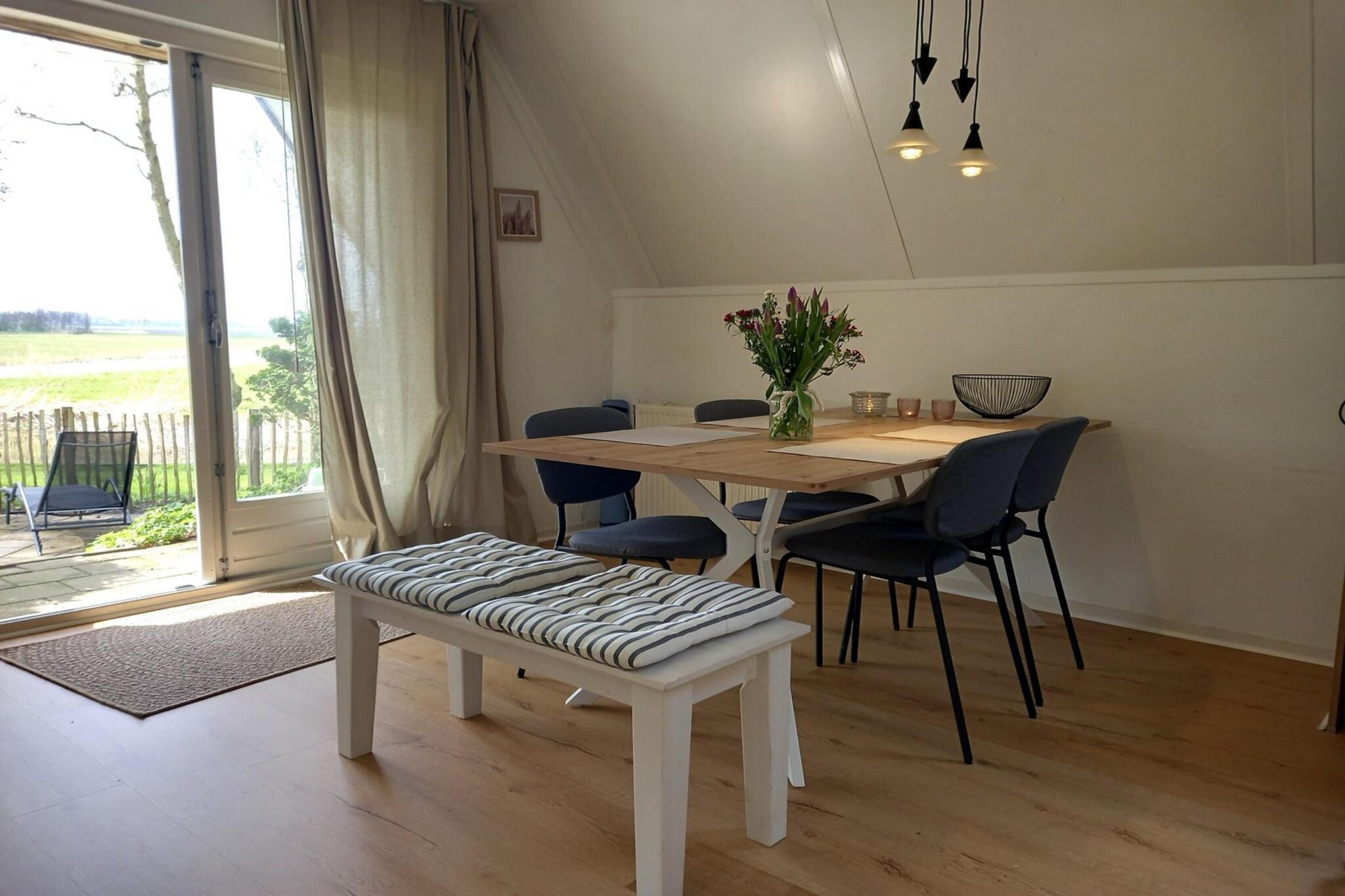 This inviting holiday home is perfect for families or small groups looking for a peaceful break close to the coast. Tucked away in a quiet park with views across open farmland and grazing sheep, it offers a sense of rural calm while still being just a short drive from the sandy beaches of Petten. A private parking space makes your stay extra convenient, and with no pets or smoking allowed, the atmosphere remains fresh and family-friendly.
Inside, the living room and open kitchen form the heart of the home. The kitchen is fully equipped with everything you need—from induction hob and dishwasher to coffee maker, Senseo and toaster—while the cosy living area provides a TV, DVD player and free WiFi for evenings in. Freshly redecorated with modern furnishings, it’s a comfortable space to relax after a day at the beach or exploring the countryside.
With three bedrooms in total, the house sleeps up to six guests. One double bedroom is located on the ground floor, while upstairs you’ll find two additional bedrooms, including one with a sunny balcony. The bathroom with shower and sink is on the ground floor, and the toilet is separate. Outdoors, the west-facing garden offers plenty of privacy, ideal for unwinding in the fresh air. Fenced for security and furnished with a garden set, it’s a welcoming spot for lazy afternoons or family meals under the sky.
The bed-linen is optional and available for € 13 p.p./Stay.