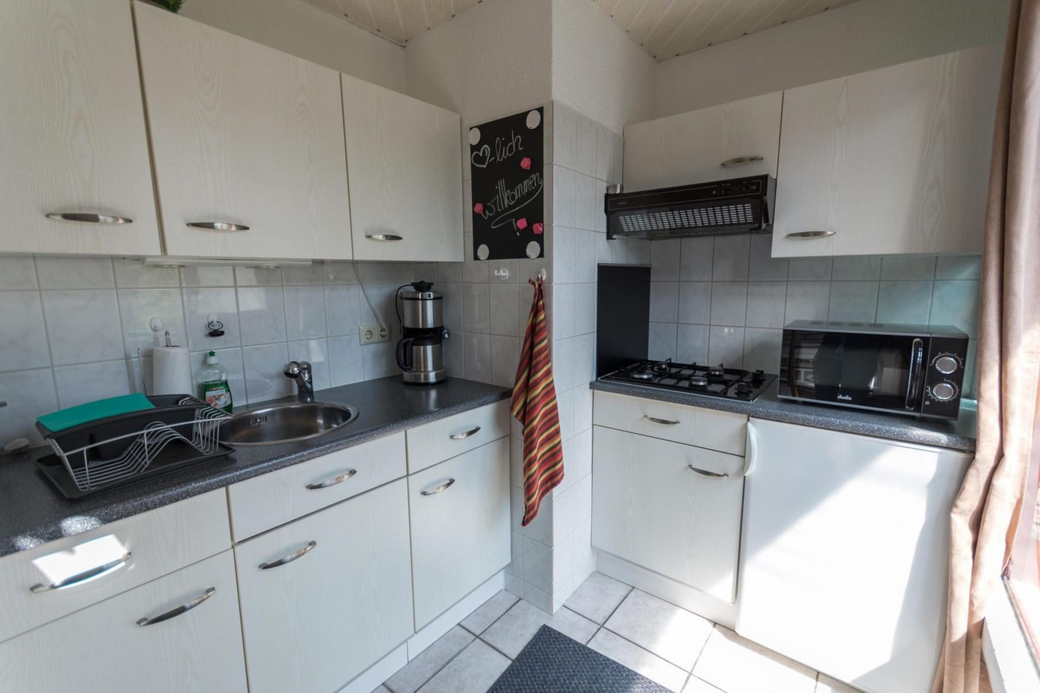 Ground floor: (Living room(TV(smart TV, german television channels), dining table, seating area), open kitchen(stove(gas), hob(gas), electric kettle, toaster, coffee machine(filter), oven, dishwasher, fridge-freezer), bedroom(double bed), bathroom(shower, washbasin, toilet))\n\nOn the 1st floor: (bedroom(single bed))\n\ncot, terrace, garden, high chair