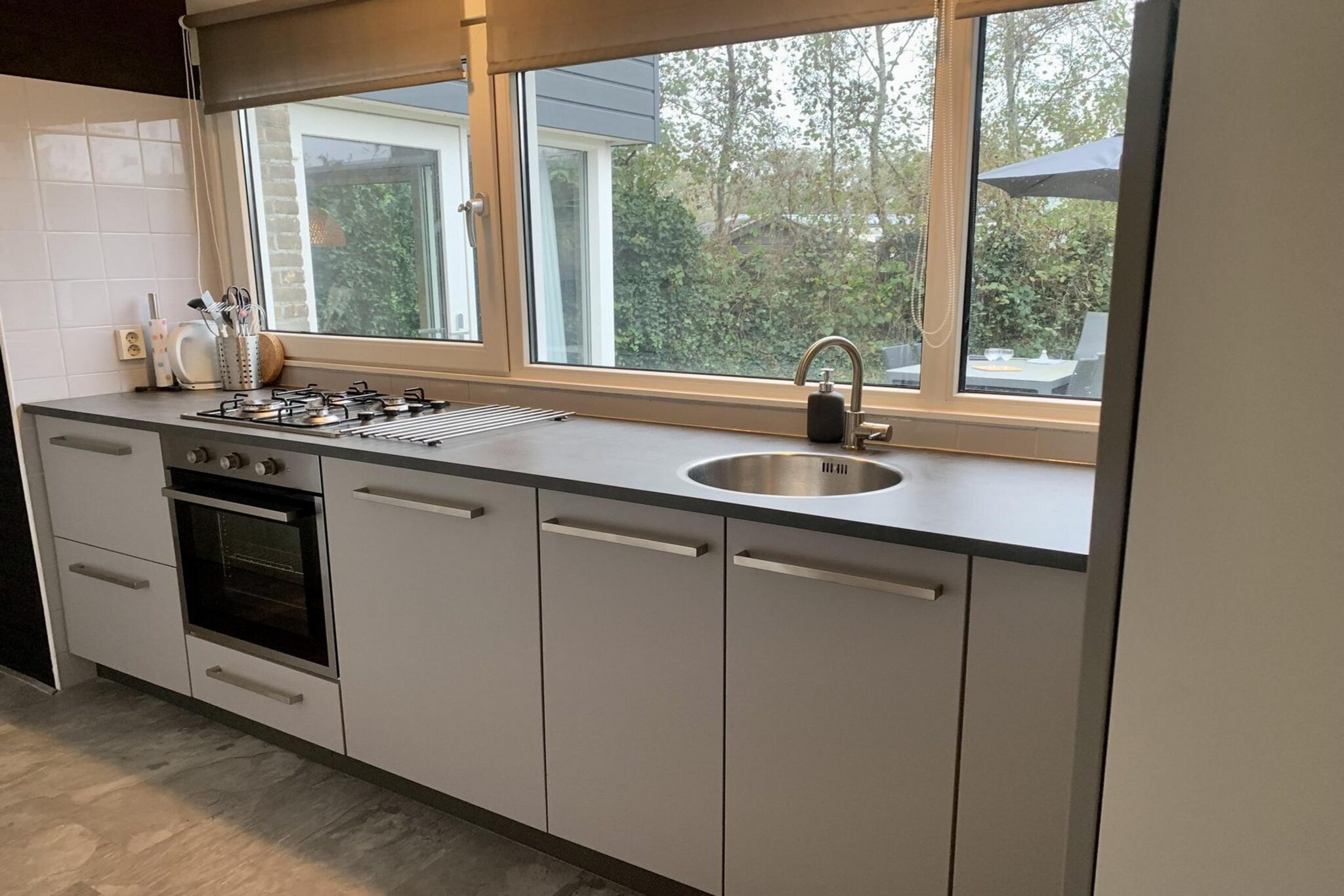 Ground floor: (open kitchen(hob(4 ring stoves, gas), electric kettle, toaster, hood, oven, microwave, dishwasher, fridge-freezer), Living/bed room(TV(cable, dutch television channels, german television channels), dining table, seating area), bedroom(double bed), bedroom(bunk bed), bathroom(shower(walk-in shower), washbasin), toilet(washbasin, toilet))\n\nwashing machine, patio, heating(central), terrace, garden, bicycle storage, garden furniture, sun loungers, parking, ironing board, iron