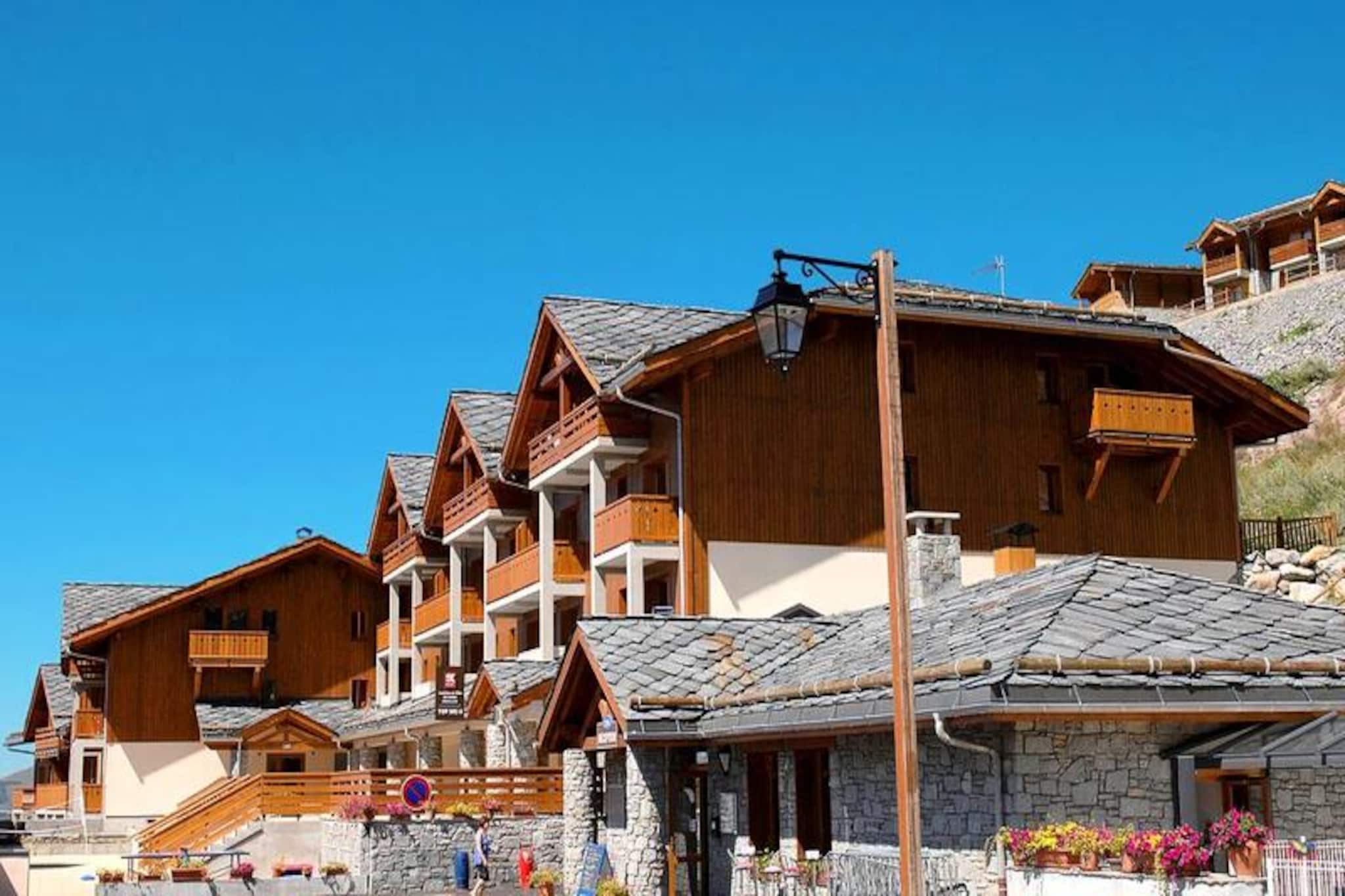 Located at the entrance to the Valmeinier resort, the Résidence Odalys Le Grand Panorama I offers a perfect getaway near the Valloire and Écrins de la Vanoise national parks. This spacious, sunny location provides access to stunning slopes, with the highest point reaching 2600 m above sea level. The residence, just 800 m from the center and 500 m from the slopes, is accessible via free shuttles and features 115 apartments in charming chalets built from stone, wood, and slate roofs. Pets are welcome, with additional charges applicable.

After an adventurous day on the slopes or exploring the area, unwind at the heated outdoor swimming pool. For those seeking more excitement, the surrounding area offers activities such as paragliding and mountain biking. The residence's cozy apartments, ranging from 35 to 40 m², include a living room with a pull-out sofa bed, a fully equipped kitchen, one bedroom with a double bed, and a second bedroom with two single bunk beds. Wifi, bed linens, and bathroom linens are included, ensuring a comfortable stay.

Additional services include end-of-stay cleaning (excluding the kitchen and dishes), a baby kit, and optional sauna access. Guests can also reserve covered parking for a fee. Whether you're relaxing by the pool or enjoying the activities, the residence provides a delightful setting for your mountain retreat.