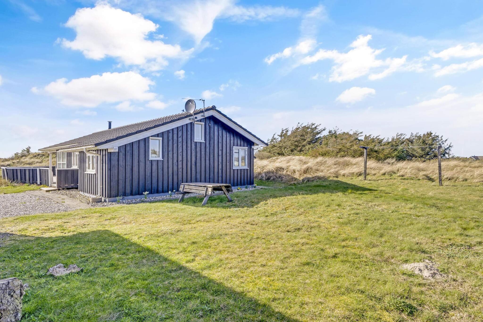 This charming holiday home offers a cozy and peaceful retreat for up to 6 people, nestled in Grønhøj just a short distance south of Løkken. Spanning 94 sqm, the house features two bathrooms, one equipped with a sauna and spa for ultimate relaxation. The three bedrooms are comfortably furnished, and the spacious kitchen-living room creates a welcoming space for dining and relaxation. A cozy loft area is perfect for children to unwind, while the living room's fireplace and views of the surrounding nature provide a tranquil ambiance. The home is non-smoking, and youth groups are not allowed.
The holiday home is located in a serene and recreational setting, just 375 meters from the beach. The area offers a quiet atmosphere while being close to popular attractions like Løkken, a bustling holiday town only 10 minutes away. Here, you can explore amusement parks, art parks, and more. Shopping is also convenient, with a local store just 350 meters away. The property is ideal for enjoying both the peace of Grønhøj and the excitement of nearby attractions, making it perfect for a family getaway.
The outdoor area includes a spacious 2674 m² natural plot, providing ample space for relaxation and outdoor activities. The lovely terraces, one of which is covered, offer the perfect spot for lounging in comfortable furniture while enjoying the surrounding nature. Whether you're soaking up the sun or taking in the quiet beauty of the area, this summer house provides a peaceful escape with everything you need to recharge.
A refundable deposit might be charged closer to your check-in date. This deposit covers utilities consumed during your stay and any additional services that may be taken. The final amount will be adjusted based on actual meter readings, actual usage of extra services, and any remaining balance will be refunded within 21 days after checkout.