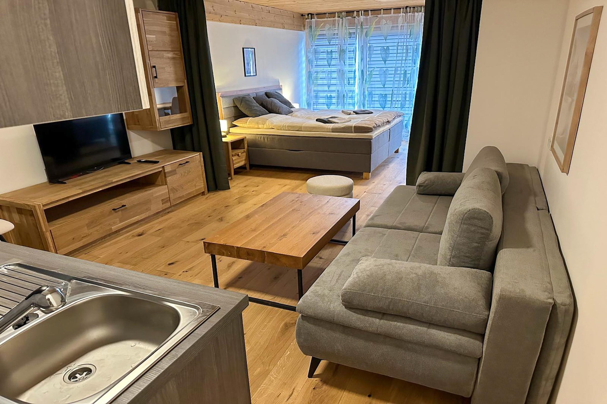 This stylish first-floor apartment comfortably accommodates up to four guests, featuring a sleeping area with a double bed and a living area with a double sofa bed, TV, and a fully equipped kitchen. Modern appliances include a kettle, coffee maker, oven, dishwasher, and refrigerator, making meal preparation effortless. The apartment also offers a contemporary bathroom with shower, sink, and toilet, as well as air conditioning for year-round comfort. Additional amenities include a lift, parking space, bicycle storage, and an electric vehicle charging station.

Saalfelden is an ideal base for outdoor enthusiasts and nature lovers. Guests can enjoy the nearby outdoor swimming pool or relax at Ritzensee. Hiking trails, sports tracks, and cross-country ski routes are easily accessible, while renowned ski areas such as Leogang, Maria Alm, Zell am See, and Kaprun are only 15–30 minutes by car, with convenient ski bus connections. Leogang is also perfect for downhill and mountain biking, and summer highlights include the family-friendly toboggan run in Saalfelden. A key box with 24/7 access ensures flexibility and convenience for your stay.