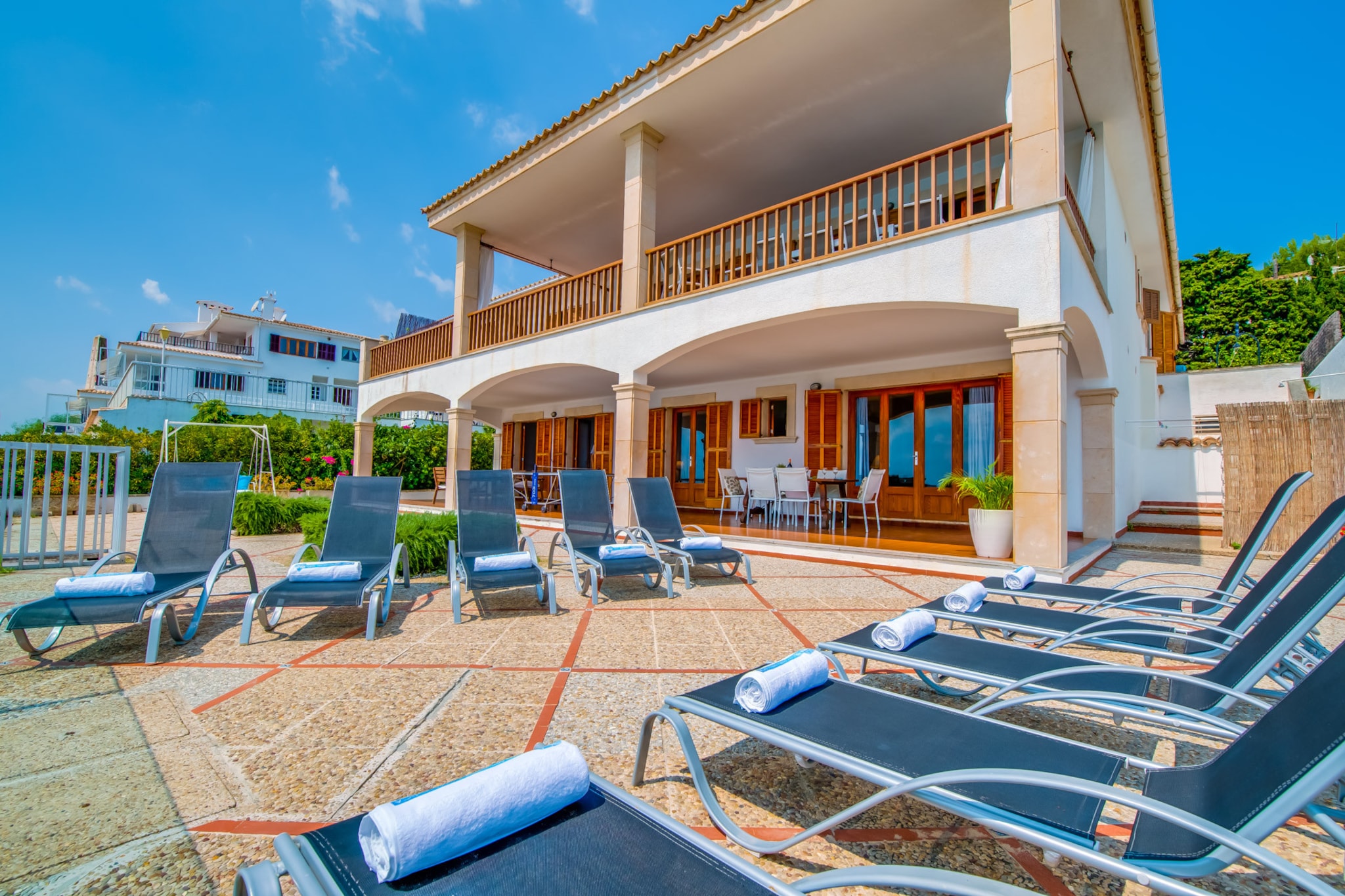 This stunning two-story seafront villa offers breathtaking views and an unforgettable holiday experience. The entrance level features a fully equipped kitchen, a cozy living room, and a bedroom with an en suite bathroom. Large windows allow the sea breeze to flow through, creating a serene atmosphere, while the 60 m² terrace stretches along the house for al fresco dining overlooking yachts and the calming sea.
The ground floor houses four additional bedrooms, including one with an en suite bathroom, and a third bathroom for convenience. Three of these bedrooms open onto a spacious 120 m² semi-covered terrace, complete with a dining area, lounge with sun loungers, and a ping pong table for fun-filled entertainment. A private footbridge leads directly to the sea, perfect for easy access to Mallorca’s crystal-clear waters.
Located in a peaceful area just 1 km from the lively Port of Alcudia, this villa offers the perfect mix of tranquility and convenience. Ideal for families or groups, Villa Can Torrens combines luxury, style, and prime location—with heating available for winter stays—making it the ultimate Mediterranean getaway.