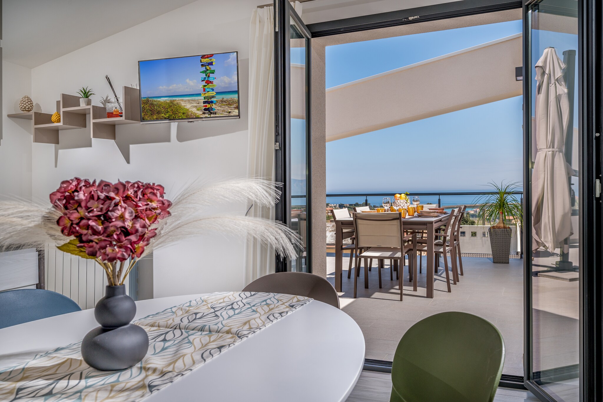 This apartment, newly built, is located in a quiet and private area, away from the hustle and bustle of the city. This setting offers guests the chance to live in a serene environment, ideal for those wishing to escape urban stress and enjoy a relaxing holiday.

One of the highlights of the property is its spacious terrace. Here, a splendid panoramic view of the gulf offers a unique visual experience. The outdoor area is equipped with comfortable deck chairs, a large umbrella for sun protection, a table, and a rocking chair, inviting moments of pure relaxation, perfect for sipping a drink or reading a book while enjoying the view.

The living area, consisting of a single open space that includes the kitchen and the living area with a sofa, is well-furnished and equipped with all necessary utensils. The kitchen also features a convenient dishwasher and a Smart TV.
The apartment has three bedrooms:
Two Double Bedrooms: Each of the two double bedrooms is air-conditioned and has a private bathroom equipped with a shower.
Third Bedroom: Equipped with a queen size bed and ventilated by a fan. In addition to the three bedrooms, there is a shared bathroom (without a shower).

The combination of modernity, comfort, and a privileged location makes this penthouse an ideal choice for those seeking an relaxing stay. Attention to detail and carefully chosen furnishings contribute to creating a welcoming and relaxing atmosphere, perfect for holidays, short or long stays, in a setting that blends natural beauty with convenience.
