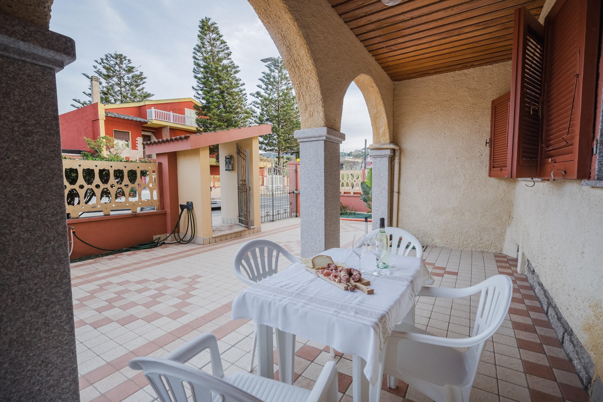 Ground floor: (Living room(TV, dining table, fireplace, seating area), open kitchen(hob, hood, oven, fridge-freezer), bedroom(double bed), bedroom(single bed, single bed), bathroom(shower, toilet, bidet, washing machine))\n\nterrace, garden furniture, parking