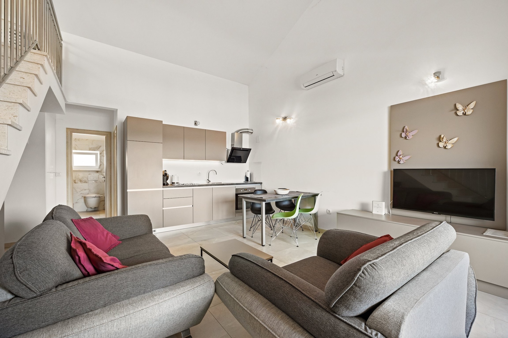 This property, with its modern decor and serene sea views, is an ideal retreat for families or small groups. The apartment comfortably accommodates up to 4 adults and 2 children, offering privacy and space for everyone. It features two bedrooms—one with a king-size bed and the other with two single beds—and two bathrooms. The gallery area provides a perfect space for children, with room for two extra airbeds. A covered terrace provides privacy and protection from the sun, while the apartment’s balcony offers a picturesque view of the Adriatic Sea. One parking space is included, with the option to request an additional space in the garage.
The apartment is situated in a peaceful residential area, just 400 meters from the center of Cres and its beautiful beach. Cres island is easily accessible via ferry from Brestova-Porozina, making it a convenient destination for travelers. The island, rich in history, was once part of the Apsyrtides in ancient Greek mythology and is home to beautiful gulfs and pristine waters ideal for swimming and exploring. With its historic significance and natural beauty, Cres is perfect for nature lovers and history enthusiasts alike.
The apartment includes a fully equipped kitchen with modern appliances such as an induction stove, refrigerator, and oven. It also offers essential amenities like air conditioning, Wi-Fi, and a flat-screen TV for entertainment. The two bathrooms feature showers, and the apartment is fitted with necessary items like a hairdryer and towels. With the added bonus of a private balcony, air conditioning, and secure parking, guests will enjoy a comfortable and relaxing stay in this charming vacation home.