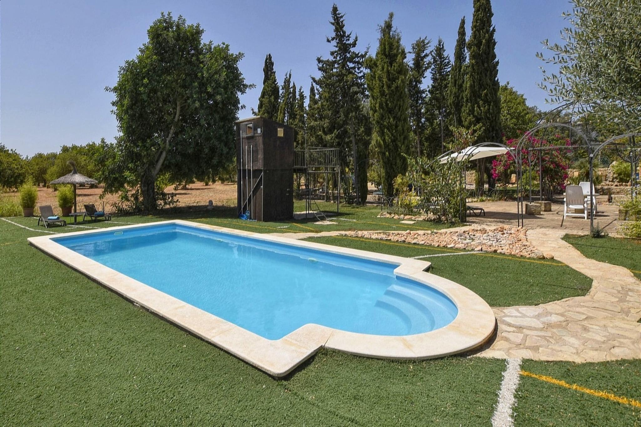 Escape to the heart of Mallorca, a charming countryside retreat nestled between Santa Maria and Buñola, right at the foot of the majestic Tramuntana Mountains. Surrounded by peaceful landscapes and just a few minutes from the vibrant village of Santa Maria, this rustic yet lovingly furnished estate offers a tranquil setting for unforgettable holidays.
Spread across two floors and 120 m² of living space, the house comfortably accommodates up to six guests in three cozy bedrooms and three bathrooms. Whether you're unwinding in the airy lounge, enjoying quiet moments on the mezzanine with a good book, or preparing a local dish in the fully equipped kitchen, every corner of this home invites you to slow down and savor the moment.
Step outside and find your own slice of paradise: a beautifully landscaped garden, a private saltwater pool (9m x 4m) with sun loungers, a shaded terrace perfect for alfresco dining, and even a built-in barbecue area. Kids will love the elevated playhouse, while adults can enjoy light workouts in the small gym area beside the pool. For cyclists, a dedicated bike storage area makes it easy to explore the scenic trails nearby.
Whether you're traveling with family, a group of friends, or looking for an active getaway in nature, Sa Caseta is your ideal home base in Mallorca—where rustic charm meets modern comfort in a setting that's both serene and inspiring.