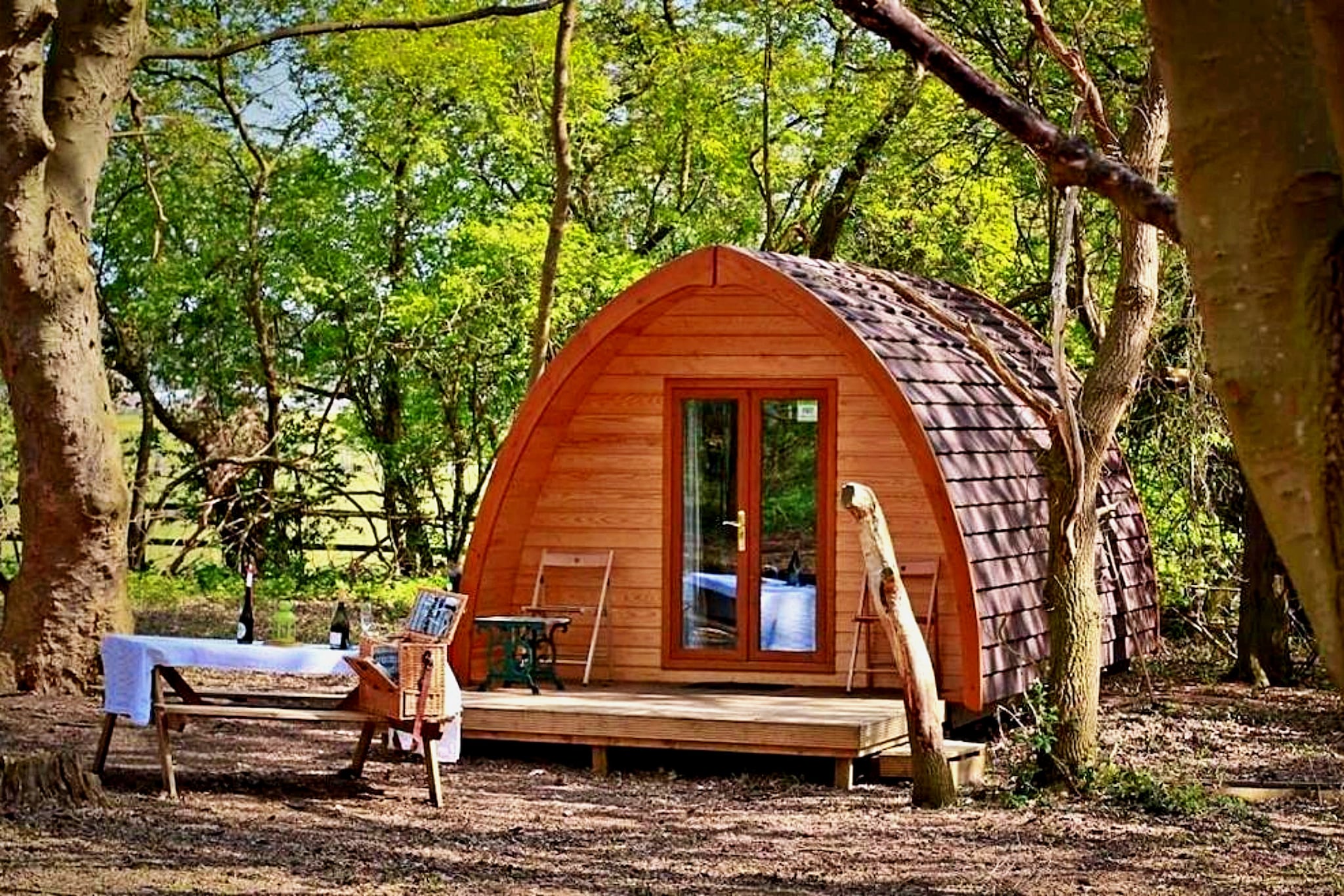 Reconnect with nature in comfort at this charming Suffolk glamping retreat nestled within private woodland near Bury St Edmunds. Part of a collection of four beautifully designed MegaPods—Aelfred, Boudicca, Eadmund, and Wulfrun—this eco-friendly accommodation offers a peaceful escape for families, couples, or small groups seeking outdoor adventure with modern comforts.
Each fully self-contained MegaPod comfortably sleeps up to four guests and is situated approximately 80 feet apart from the others, providing privacy and tranquility in a serene woodland setting. All pods are pet-friendly, welcoming your furry friends to join in the outdoor fun. The well-equipped amenities include a private bathroom with shower and WC, a kitchenette with toaster, kettle, and microwave, as well as a TV, mini fridge, and wireless internet — ensuring a cozy, convenient stay.
Step outside to enjoy the outdoor BBQ and seating area, perfect for relaxing and dining amidst the natural beauty of Suffolk’s countryside. Bedding and towels are included, and on-site parking makes your arrival hassle-free. Whether you're seeking a romantic retreat, a family adventure, or a group getaway, this woodland glamping experience offers an idyllic setting immersed in nature’s tranquility.