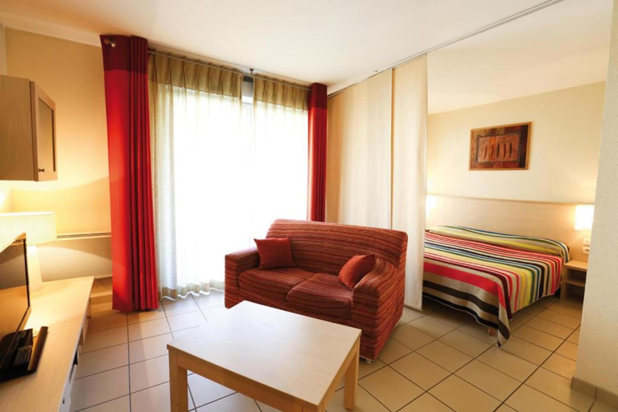 Tucked at the foot of the Haut-Jura Regional Natural Park and just moments from the Swiss border, Adonis Divonne-les-Bains invites you to experience serenity in an exceptional setting. This internationally renowned spa town offers the perfect blend of revitalizing mountain air, breathtaking Alpine scenery, and easy access to Lake Geneva, Mont Blanc, and the vast forests of the Jura.

Whether you're planning a relaxing escape or an outdoor adventure, our spacious apartments are designed to make your stay seamless and comfortable. Each unit accommodates up to 10 guests and features a private balcony or terrace—ideal for soaking in the pure mountain air and spectacular natural surroundings. Inside, the apartments are equipped with everything you need for independent living: a ceramic hob, oven, dishwasher, and all necessary dishes and cutlery. The open-plan living and bedroom area includes a comfortable double bed, a flat-screen satellite TV, and a cozy seating space for unwinding after a day of hiking, cycling, or lakeside picnics.

Enjoy the comfort of air conditioning, a private bathroom with bathtub or shower, and convenient amenities such as a minibar and safe. Whether you're traveling solo, with a partner, or in a group, Adonis Divonne-les-Bains offers a peaceful base to explore the cultural and natural riches of the region.

From alpine trails and lake cruises to spa indulgence and scenic drives through Switzerland, your journey begins here—where tranquility meets the mountains.
