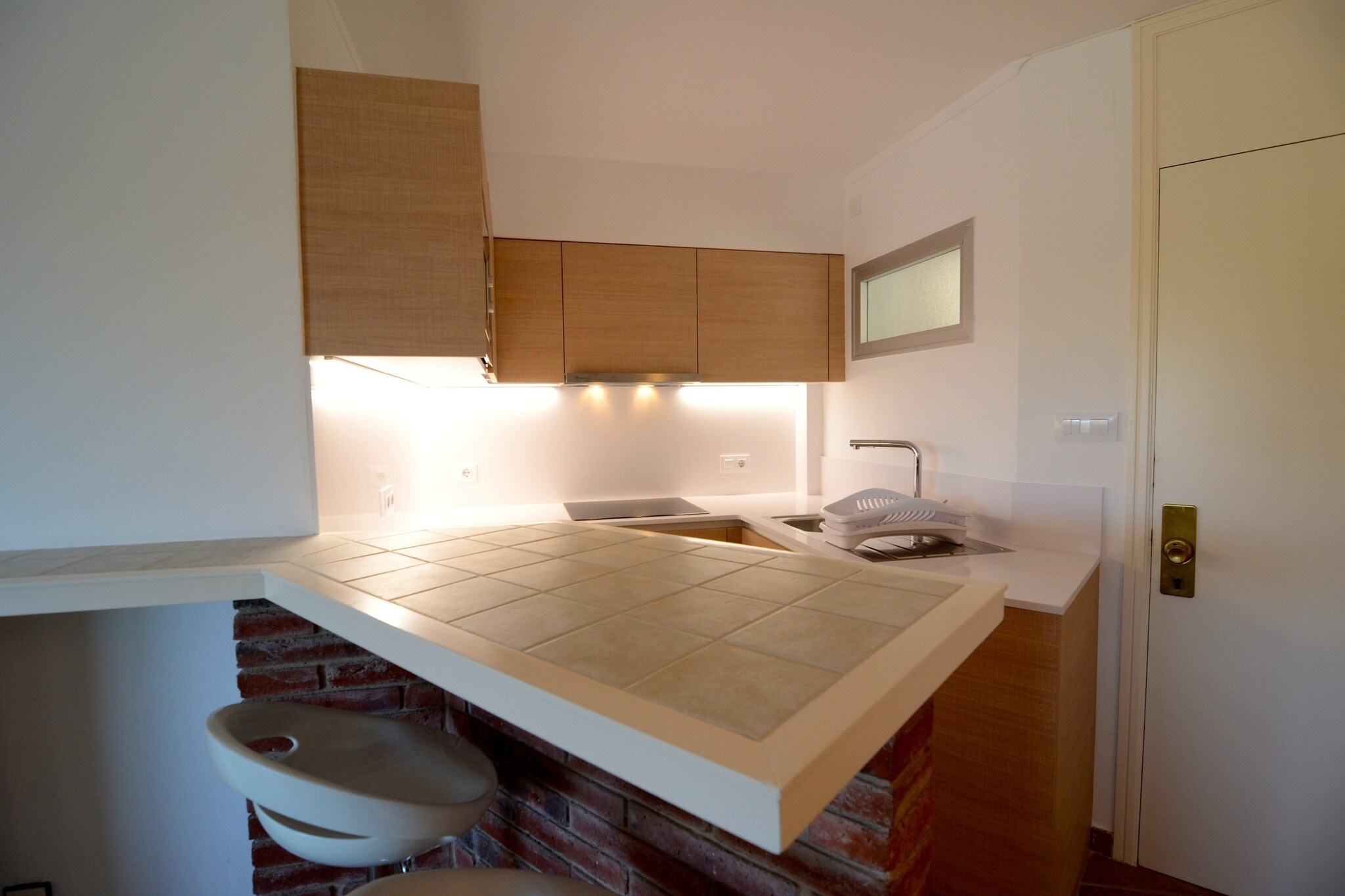 This comfortable apartment offers a well-lit 50 m² space with two bedrooms, accommodating up to four guests. It is designed for relaxation with an 8 m² private terrace, outdoor furniture, and access to a communal swimming pool with a children’s section. The apartment is equipped with air conditioning in the living room, a heat pump, Wi-Fi, a TV, and a radio. A washing machine and iron add to the convenience. Situated in a residential area next to the sea, the property is accessible via an elevator. Pets are not allowed.  
Perfectly located just 150 meters from the sandy beach, the apartment is ideal for enjoying coastal activities. The city center, with its lively cafes, restaurants, and shops, is also within 150 meters, providing easy access to local attractions. A supermarket is only 200 meters away, ensuring convenience for grocery shopping. Golf enthusiasts can visit Empordà Golf Club, located 9 km from the property. The train station in Flaçà is 35 km away, and Girona-Costa Brava Airport is 55 km from the accommodation.  
The open-plan kitchen is fully equipped with a glass-ceramic hotplate, refrigerator, microwave, oven, and dishwasher, making meal preparation simple. Guests have access to dishes, cutlery, and essential cooking utensils. Additional appliances such as a coffee machine, toaster, and juicer offer extra convenience. A well-maintained washroom provides modern amenities for a comfortable stay.