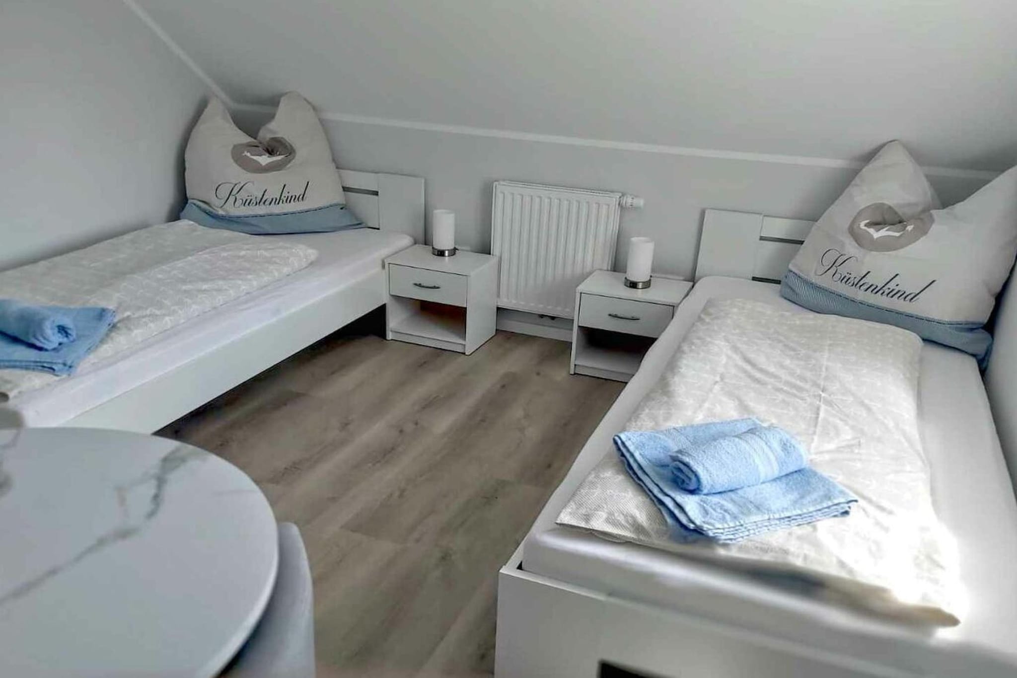 On the 1st floor: (Kitchen(Egg Cooker, Mixer, Spices, Kitchenette, TV, dining table, stove, hob, electric kettle, toaster, coffee machine, microwave, dishwasher, fridge, freezer), Living/diningroom(Armchair, Sofa, TV, dining table), bedroom(Wardrobe, single bed, single bed, TV), bedroom(Wardrobe, double bed, TV), bathroom(Mirror, toilet, shower, washbasin, heating, hairdryer), guest toilet(Mirror, toilet, washbasin))\n\nFire Alarm, Vacuum Cleaner, Internet access, First Aid, balcony(Sun Umbrella, balcony), parking, ironing board, iron