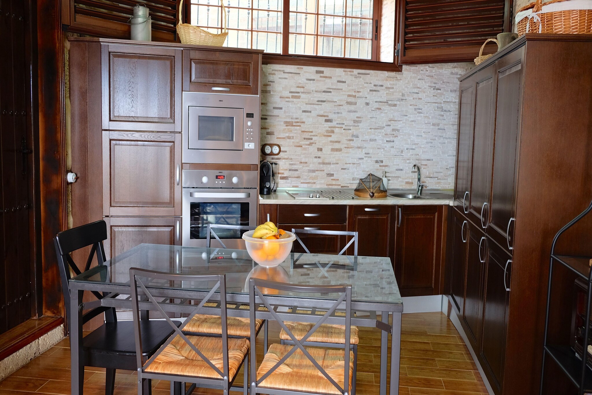 Ground floor: (Entrance(reachable from the outside), open kitchen(hob(2 ring stoves, electric), electric kettle, hood, coffee machine, oven, microwave, dishwasher, fridge-freezer), Living/diningroom(TV(flatscreen, satellite, digital, international television channels), dining table, seating area), bedroom(double bed(150 x 200 cm)), bedroom(single bed(90 x 190 cm), single bed(90 x 190 cm)), bathroom(shower, washbasin, toilet, hairdryer), bathroom(reachable from the outside)(shower, washbasin, toilet))\n\nwashing room(washing machine, ironing board, iron), garden doors, terrace, garden furniture, BBQ, swimming pool(private, heated, indoor, opened from Jan upto and including Dec)