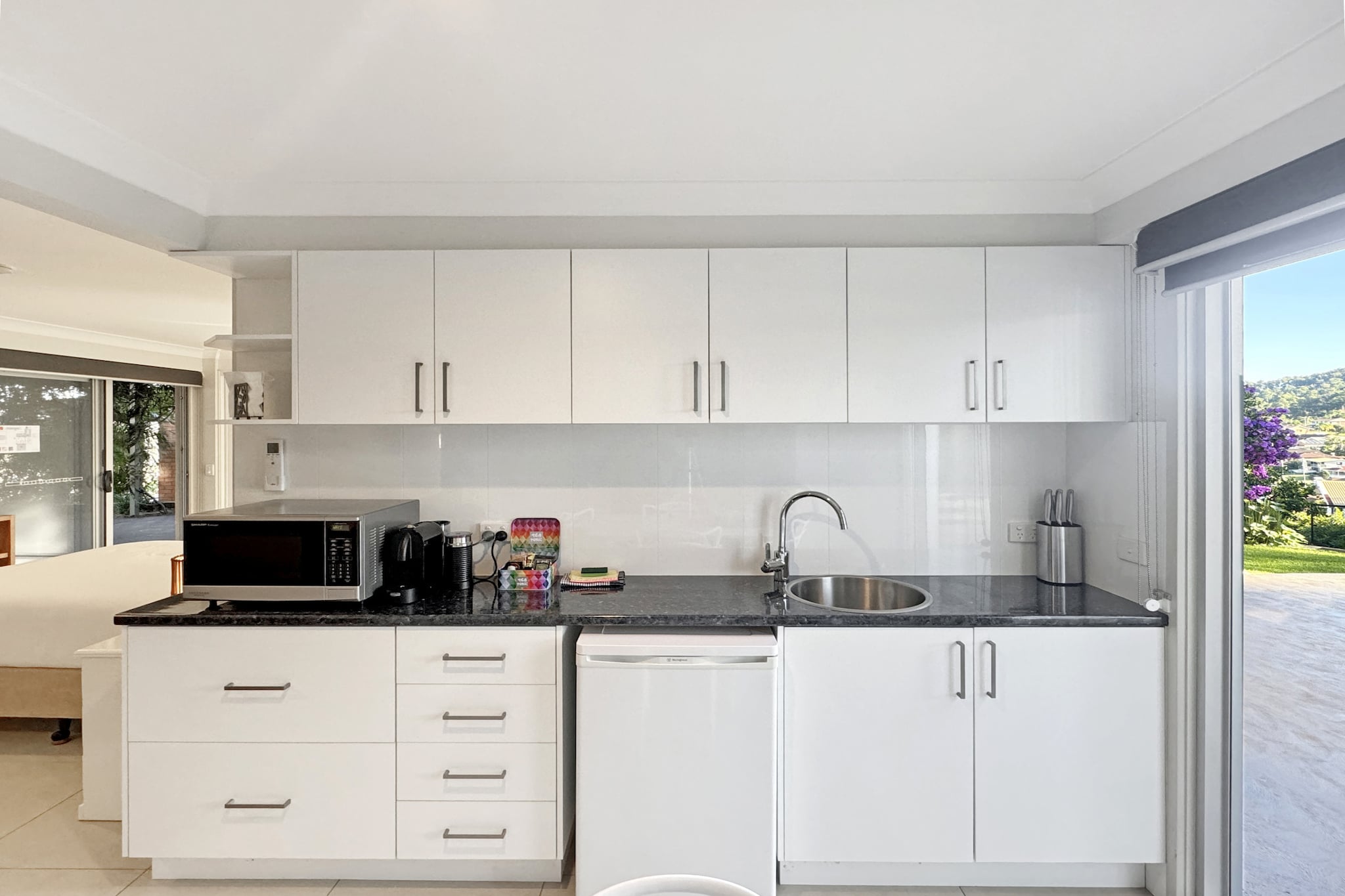 This generously spacious studio is conveniently located mere minutes from Denhams Beach, Wimbie Beach and other local attractions. Featuring sleek interiors, the property is set amidst a natural landscape offering convenience for travellers seeking to explore the beautiful Surf Beach region. With modern interiors and close proximity to amenities, this property makes the perfect refuge for a couple looking for natural beauty on a romantic getaway.
The space
Start your day just steps away from breath-taking beaches, national parks, and scenic trails, perfect for a weekend of adventures. Tucked in the heart of Surf Beach, this spacious studio features a comfy bedroom, a generous bathroom, a cosy dining and cooking area, and an exceptional outdoor space perfect for alfresco meals. Featuring air conditioning, on-site parking, and self-check-in, your stay will feel as smooth as the morning ocean breeze. This property is a haven crafted for unforgettable memories.
Living room
- Couch sits 2 people
- TV with free-to-air
Kitchen & Dining Area
- Fully equipped with utensils and cutlery
- Dining area sits 4 people
Bathroom & Laundry
- Laundry room available with washer and dryer
- Travel essentials, towels and hairdryer provided
Amenity Notes
- Only access to the downstairs area of the house.
- Split A/C (heating + cooling)
- Portable fan available
- Wi-Fi available
- Driveway parking (shared driveway) for a medium sized car
- Amenity access: Shared back garden with al fresco dining