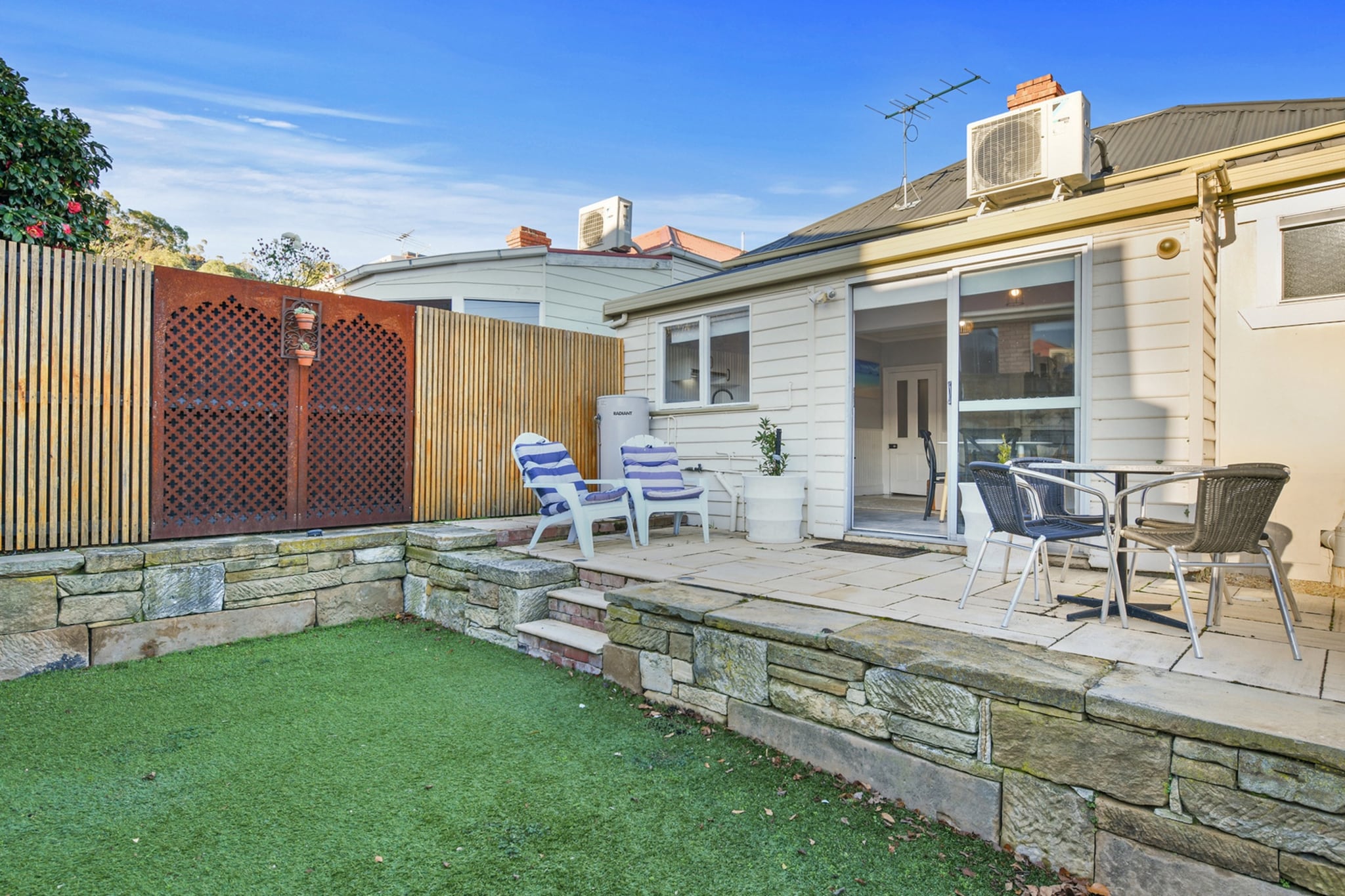 This charming 2-bedroom cottage blends 120 years of character with modern comforts. Featuring polished timber floors, a well-equipped kitchen, fast Wi-Fi, and self-check-in, itâ€™s ideal for couples or friends. Enjoy a private outdoor area, on-site laundry, and secure gated parking. Located in vibrant North Hobart, just a 10-minute walk to the dining and cafÃ© strip and 25 minutes to the CBD, with local favourites like Trophy Room cafÃ© nearby.
The space
Set behind a secure gated entrance in vibrant North Hobart, this charming two-bedroom home blends classic character with modern comfort. Featuring polished timber floors, high ceilings, and period fireplaces, the space offers warmth and elegance throughout. Both queen bedrooms are fitted with quality linens and ample storage, while the open-plan living area includes a leather couch, TV, split-system heating, and a second fireplace for cosy evenings in. The fully equipped kitchen comes with an electric stove, oven, microwave, fridge, and cafÃ©-style coffee machine, opening onto a private, fully fenced courtyard with outdoor seating. A stylish bathroom with a walk-in shower and a combined laundry with washer, dryer, and ironing facilities complete the home. With secure gated parking and a front verandah to enjoy the street views, this is the ideal retreat for exploring Hobartâ€™s cultural sights and natural beauty.
 
Living Room
- Couch seats 3 people + armchair
- TV with free-to-air channels and streaming apps (guests to use their own credentials)
 
Kitchen & Dining Area
- Fully equipped with cutlery and utensils
- Electric stovetop, microwave, oven and coffee machine
- Dining area seats 4
 
Bathroom & Laundry
- Laundry room available with washer and dryer
- Travel essentials, towels and hairdryer provided
 
Amenity Notes
- Onsite parking behind gates, access via Letitia St
- Reverse cycle A/C (heating + cooling) in living room
- Wi-Fi is available
- Decorative fireplaces in the living area and both bedrooms
- Private outdoor seating area for 4 in rear courtyard
Local area description
Located in vibrant North Hobart, this home offers easy access to iconic eateries, heritage pubs, and the beloved State Cinemaâ€”one of Australiaâ€™s oldest independent cinemas. Just minutes from the CBD, it's the perfect base for exploring Salamanca Market, MONA, and Mount Wellington. The neighbourhoodâ€™s tree-lined streets, historic buildings, boutique shops, and diverse dining options create a relaxed, cultural atmosphere ideal for discovering the best of Hobart
House rules
You are staying in a friendly and peaceful neighbourhood and we kindly ask you to respect the community and your surrounding neighbours. The following strict House Rules apply:
 
- No loud noise between 10 pm and 8 am
- No parties or antisocial behaviour
- No additional people are to access the property without our prior approval
- No pets are allowed in the property without approval
- No smoking is allowed at any times
- If you break something, please let us know
- To help protect all floor coverings, do not wear any shoes inside the property
 
Please be aware that excessive noise such as amplified music, vocals or screaming or anti-social behaviour in the property or common areas can cause neighbours to complain to us, the Building Manager, Council Rangers or Police.
 
IMPORTANT:
- Any breach of the House Rules may lead to a $500 fine plus compensation for any cost/damage created and immediate eviction of the property without refund.
- Pets are available on request unless the property states it is pet-friendly. Any stays with pets will incur an additional cleaning fee of $200.
 
Finally, when checking out, we kindly ask you for the following:
 
- Please leave all beds unmade
- Please clean up your dishes and put them away
- In case you have rearranged furniture, please put it back to the original location
- Please take out the rubbish and remember to use the right bins
- Please ensure all appliances, A/C and lights are off and doors and windows are closed.
- Please check your accommodation thoroughly before departing to avoid any unintentional items left behind.
 
We are not liable for any items left behind after your stay. In the rare event that a guest reports a missing item, we will make every effort to locate it for you, but we cannot guarantee its retrieval. If the item is found, we will gladly assist in arranging its return to an address within Australia, subject to postage and service fees.
Interaction with guests
Welcome to MadeComfy! Our local team curates stays in exceptional Australian & New Zealand properties, ensuring style, comfort, and prime locations for discerning guests. We prioritise your needs to provide a memorable home-away-from-home experience. Explore our digital guidebooks for local recommendations, and don't hesitate to contact us throughout your stay. We're here to ensure your comfort - enjoy your stay with MadeComfy.
Notes
-Stairs are required to access the property entrance
 
For your comfort, this property is prepared with professional-grade hotel-style linen, including a three-sheet setup, ensuring a fresh and hygienic sleep experience.
 
Extra Services:
- Early Check-in: Our standard check-in is at 3 pm. To guarantee early access to the property we suggest booking the night before if available. Otherwise, early check-in is subject to availability from the night before at an additional cost.
- Late check-out: Our standard check-out is at 10 am. To guarantee a later check-out of the property we suggest booking an additional night if available. Otherwise, a late check-out is subject to availability from the night before to an additional cost.
- Baggage: For security reasons, we are unable to receive or to keep unattended baggage before check-in or after check-out
- We provide a small welcome amenity pack to get your stay started.
- This booking is protected with coverage for lost baggage and emergency medical expenses, provided by Travel Support with claim upto 500 AUD (T&C Applies). For more details reach out to Guest Support team post booking.
Access description
Key collection is onsite. Further details will be provided 3 days before check-in if your booking is successfully reserved. Access to the property requires stairs.
Getting around
Metro Tasmania buses from nearby Elizabeth Street reach Hobart CBD in around 10 minutes and connect to wider Hobart areas
 
Hobart Airport is just a 15â€“20 minute drive away
 
The CBD is only 5 minutes by car or a short bus ride
 
MONA ferry terminal is a 30-minute walk or a 5-minute drive
 
Neuron and Beam e-scooters are available to rent via apps, Taxis and Uber are widely available and Car hire options are easily accessible for day trips and exploring beyond Hobart