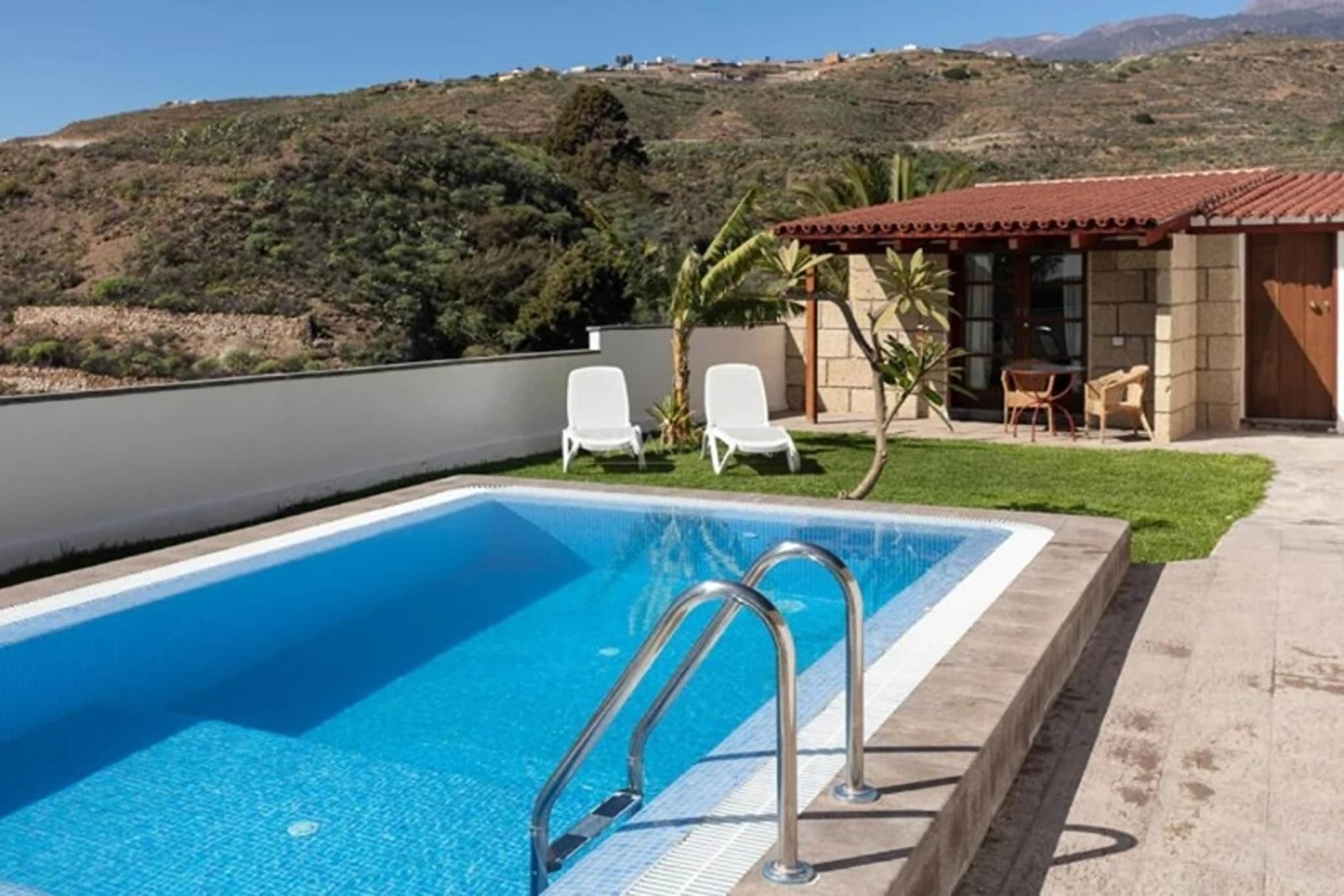 Tucked within a historic 18th-century rural estate, this charming holiday home is part of a beautifully restored Canarian complex where tradition and tranquillity come together. Surrounded by 2,000 m² of gardens, fruit trees and quiet pathways, the property preserves the soul of old Tenerife with stone walls, wooden beams and a warm, rustic character. The scent of bougainvillea fills the air as you enter the private grounds your own peaceful corner of the island.
Inside, the house combines traditional architecture with modern comfort. The open kitchen and cosy living-dining area create a welcoming space to cook, relax and unwind, while large garden doors open onto your private terrace. Two serene bedrooms one with a king-size bed and one with a double bed ensure restful nights, and the bathroom is equipped with essential comforts including a shower and hairdryer. With a flatscreen TV, satellite channels, and a sofa bed, the home is thoughtfully designed for both quiet mornings and relaxing evenings.
Step outside to your private garden, complete with comfortable furniture, a BBQ and a sparkling private pool available year-round. Enjoy breakfast on the terrace, soak up the sun by the pool, or spend evenings under the stars in the covered porch. Surrounded by nature and the timeless beauty of traditional Canary architecture, this rural retreat offers an intimate, authentic escape perfect for those seeking calm, comfort and the true spirit of Tenerife.